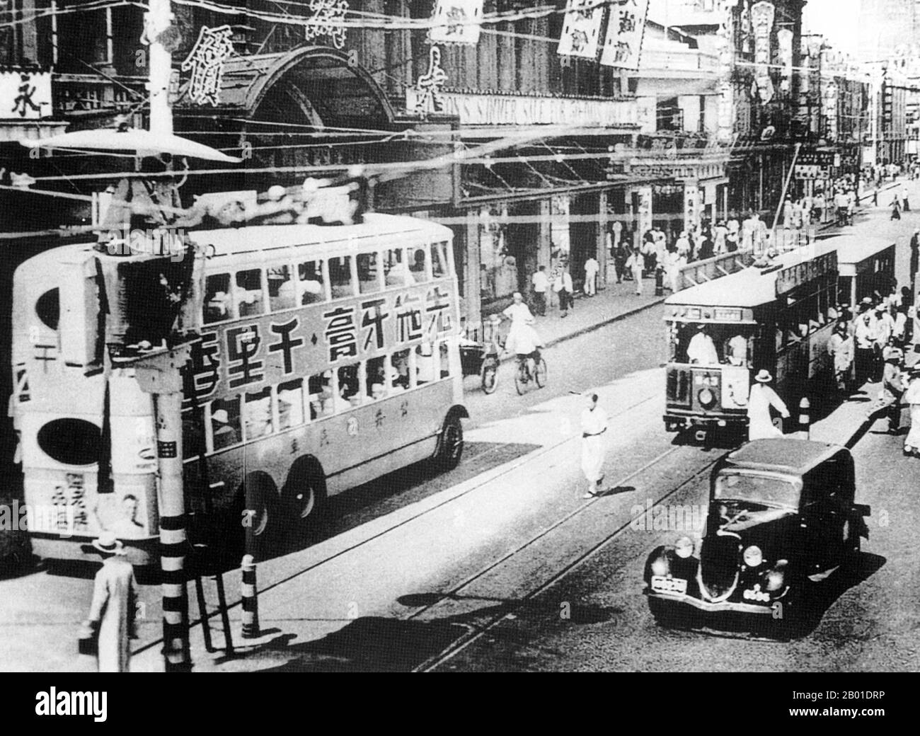 China: Shanghai Verkehr - Bus, Straßenbahn und Auto - auf Nanjing Road, c. 1930. Shanghai (Chinesisch: 上 海; Pinyin Shànghǎi) ist eine der größten Städte nach Einwohnern in der Volksrepublik China und der Welt. Die Stadt befindet sich im Osten Chinas, im mittleren Teil der chinesischen Küste, und liegt an der Mündung des Jangtse-Flusses. Aufgrund ihres raschen Wachstums in den letzten zwei Jahrzehnten ist sie wieder zu einer globalen Stadt geworden, die Einfluss auf Finanzen, Handel, Mode, Technologie und Kultur ausübt. Shanghai war einst eine reine Fischerei- und Textilstadt und gewann im 19. Jahrhundert an Bedeutung. Stockfoto