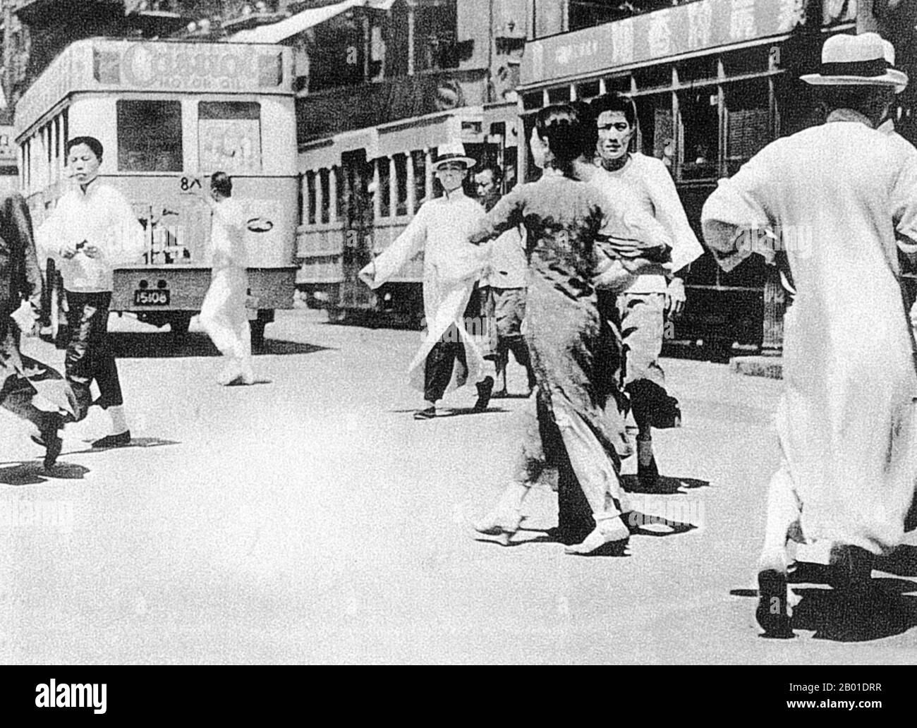 China: Fußgänger und Busse auf einer Shanghai Road, 1920er. Shanghai (Chinesisch: 上 海; Pinyin Shànghǎi) ist eine der größten Städte nach Einwohnern in der Volksrepublik China und der Welt. Die Stadt befindet sich im Osten Chinas, im mittleren Teil der chinesischen Küste, und liegt an der Mündung des Jangtse-Flusses. Aufgrund ihres raschen Wachstums in den letzten zwei Jahrzehnten ist sie wieder zu einer globalen Stadt geworden, die Einfluss auf Finanzen, Handel, Mode, Technologie und Kultur ausübt. Shanghai war einst eine Fischerei- und Textilstadt und gewann im 19.. Jahrhundert aufgrund seiner günstigen Hafenlage an Bedeutung. Stockfoto