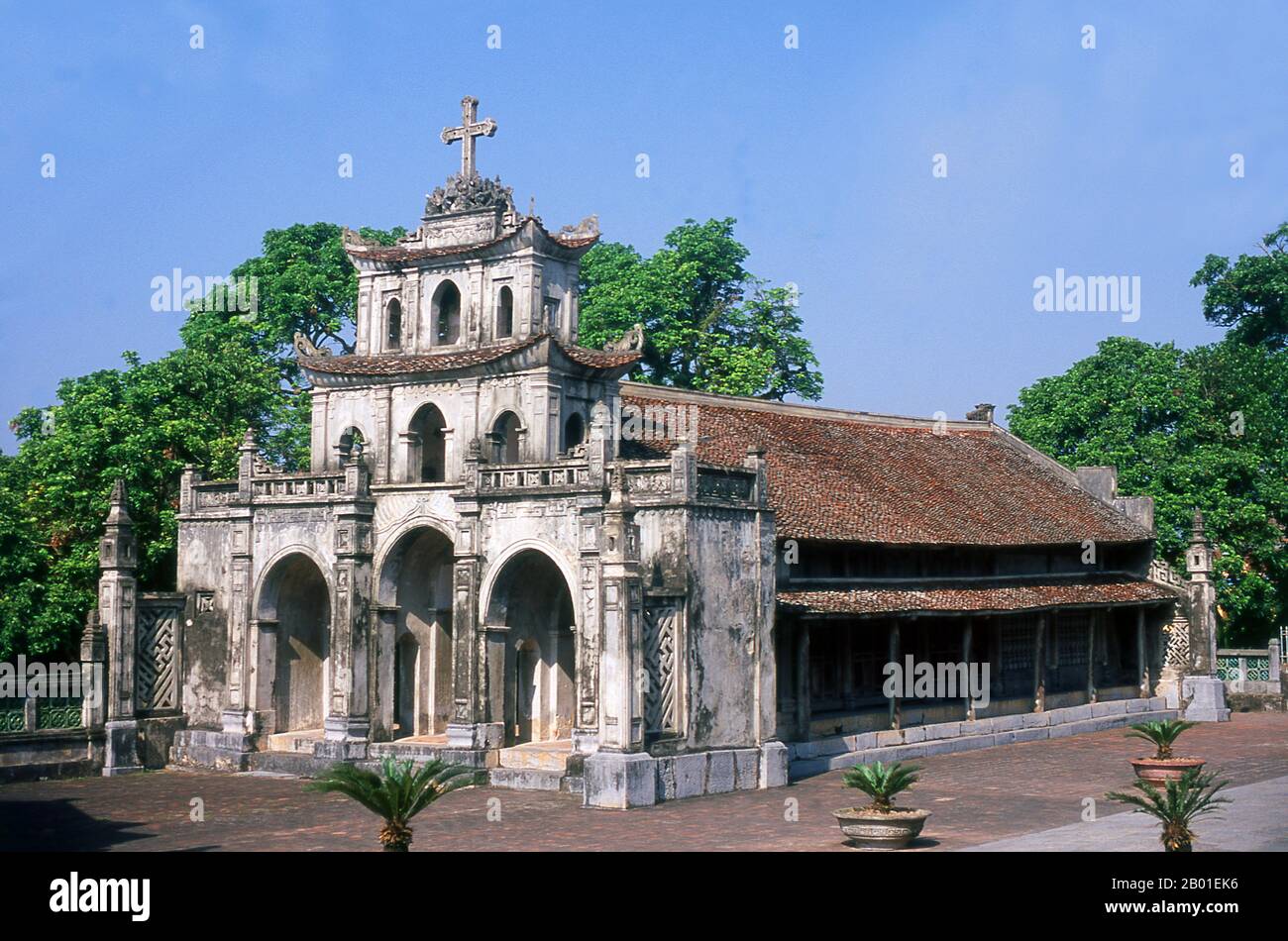 Vietnam: Äußere Kapelle in der Phat Diem Kathedrale, Phat Diem, Provinz Ninh Binh. Die Kathedrale Phat Diem befindet sich im Bezirk Kim Son der Provinz Ninh Binh. Es ist eine der berühmtesten und ungewöhnlichsten Kirchen in Vietnam, und die Architektur ist eine Synthese chinesisch-vietnamesischer und französisch-katholischer Stile. Der Katholizismus kam zu früh zu Phat Diem. Alexandre de Rhodes, ein Jesuit aus Avignon, der das vietnamesische schriftsystem quoc ngu entwickelt hat, predigte hier bereits 1627, aber es war ein vietnamesischer Priester, Pater Tran Luc, der den Bau der wunderbaren Kathedrale von Phat Diem konzipierte und organisierte Stockfoto