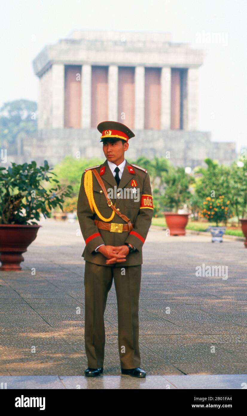 Vietnam: Wachen am Ho-Chi-Minh-Mausoleum, Ba-Dinh-Platz, Hanoi. Der BA-Dinh-Platz ist für die Vietnamesen von besonderer Bedeutung, da Ho Chi Minh hier vor einer Menschenmenge von mehr als 100.000 Menschen am 2. September 1945 die Unabhängigkeit der Nation von Frankreich erklärte. Das Mausoleum von Ho Chi Minh befindet sich auf der Westseite des Ba Dinh Platzes, einer schweren grauen Struktur, die von Stein überblickt ist, der vom Marble Mountain in der Nähe von Danang abgebaut wurde. Ho Chi Minh hat ausdrücklich darum gebeten, dass er eingeäschert wird und seine Asche in ganz Vietnam verstreut wird, was die nationale Einheit symbolisiert, der er sein Leben gewidmet hatte. Stockfoto