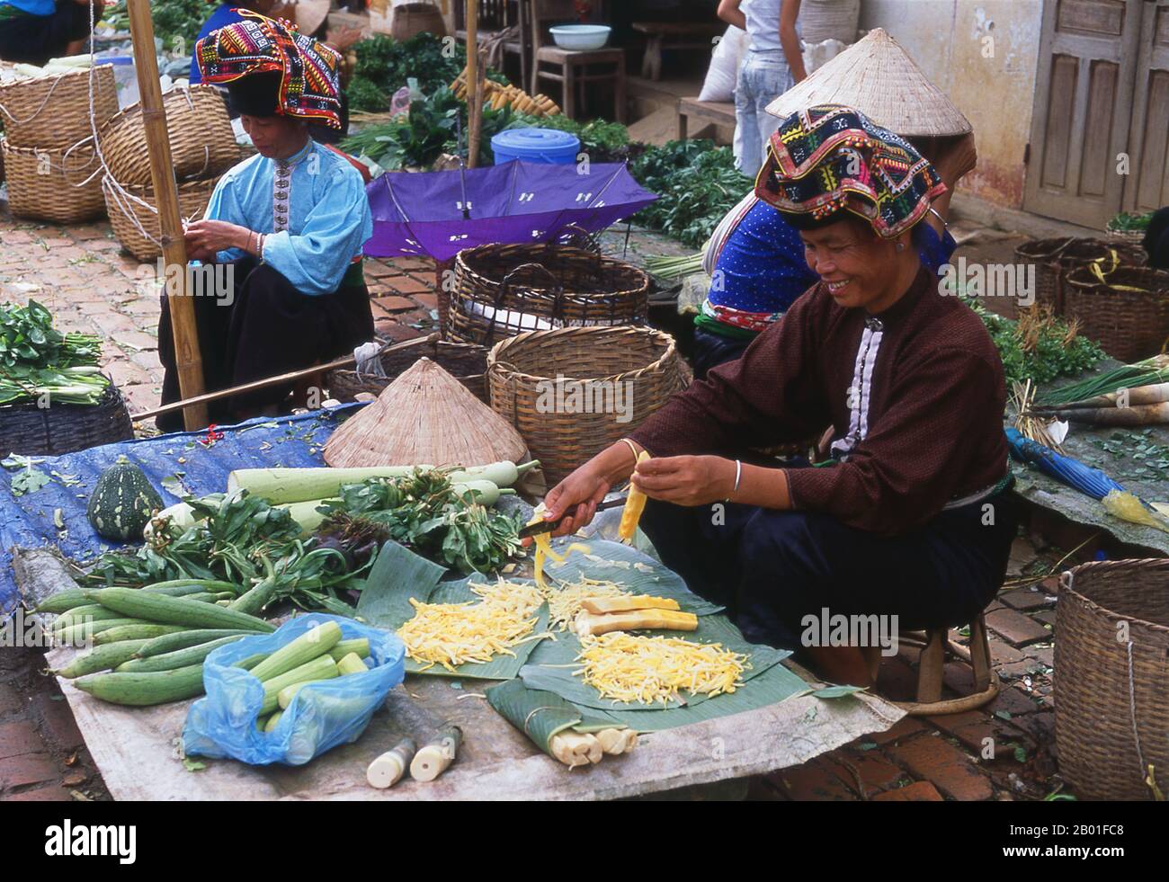 Vietnam: Tai-Frauen, die Gemüse auf dem Markt in Thuan Chau, Nordwesten Vietnams, verkaufen. In den engen Bergtälern der Provinzen Son La, Dien Bien und Lai Chau in Nordvietnam bleiben die Tai eine sehr bemerkenswerte und selbstbewusste Minderheit. Sie sind in die Gemeinden White Tai und Black Tai unterteilt, während Red Tai weiter südlich durch die laotische Grenze in den Provinzen Thanh Hoa und Nghe an vorherrscht. Diese Untergruppen zeichnen sich durch die Kleidung ihrer Frauen aus. Vietnams Tai sind Menschen in den Bergtälern. Sie sind relativ wohlhabend. Stockfoto