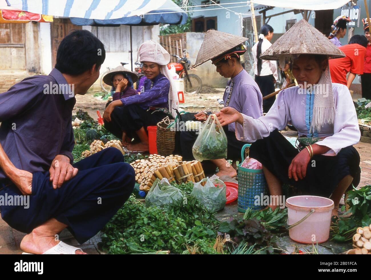 Vietnam: Tai-Frauen, die Gemüse auf dem Markt in Thuan Chau, Nordwesten Vietnams, verkaufen. In den engen Bergtälern der Provinzen Son La, Dien Bien und Lai Chau in Nordvietnam bleiben die Tai eine sehr bemerkenswerte und selbstbewusste Minderheit. Sie sind in die Gemeinden White Tai und Black Tai unterteilt, während Red Tai weiter südlich durch die laotische Grenze in den Provinzen Thanh Hoa und Nghe an vorherrscht. Diese Untergruppen zeichnen sich durch die Kleidung ihrer Frauen aus. Vietnams Tai sind Menschen in den Bergtälern. Sie sind relativ wohlhabend. Stockfoto