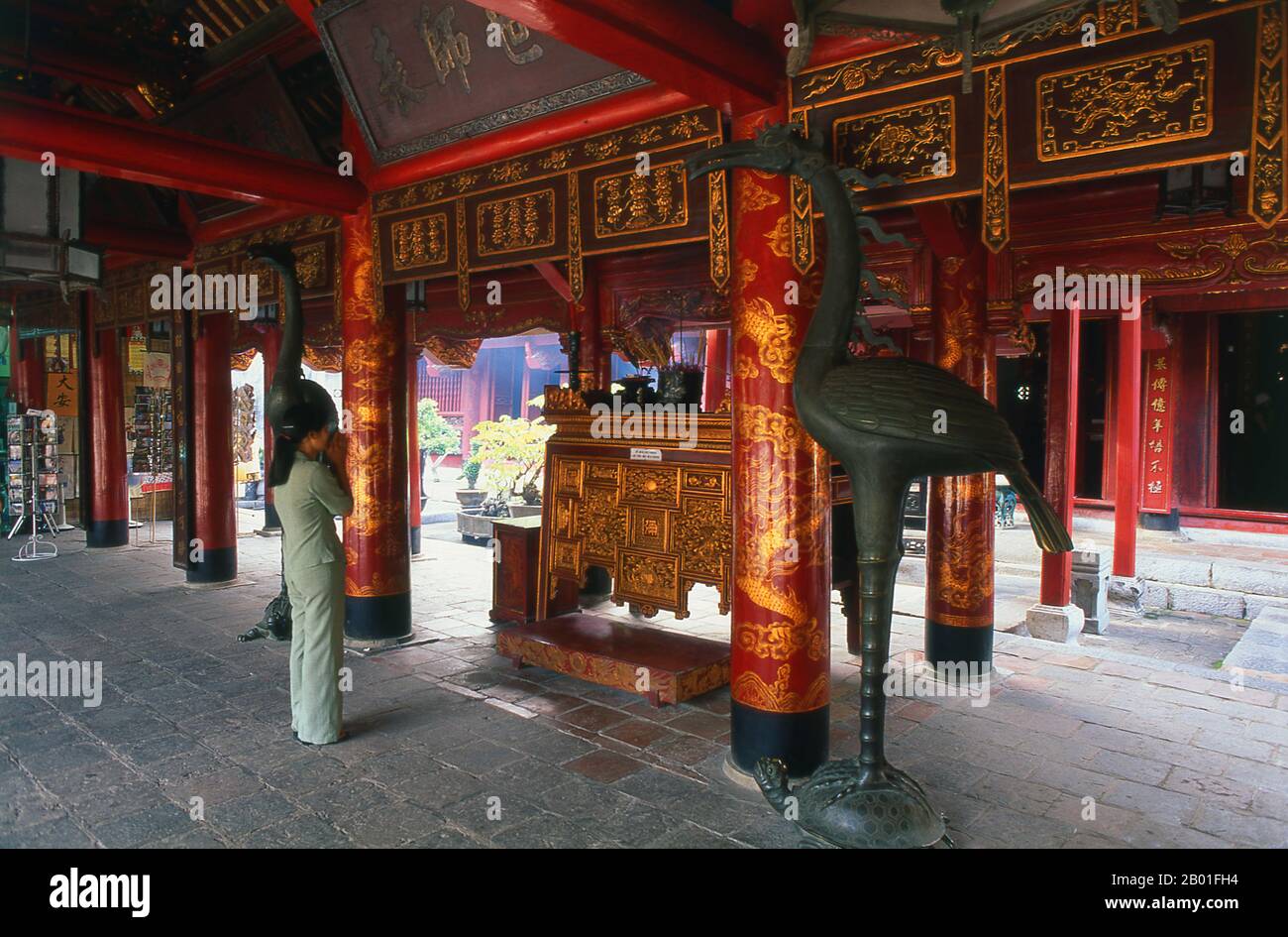 Vietnam: Verehrer am Hauptaltar, Altar des Konfuzius, großes Haus der Zeremonien, Tempel der Literatur (Van Mieu), Hanoi. Der Literaturtempel oder Van Mieu ist einer der bedeutendsten kulturellen Schätze Vietnams. Der Tempel wurde 1070 von König Ly Thanh Tong aus der frühen Ly-Dynastie gegründet und war ursprünglich Konfuzius und Chu Cong gewidmet, einem Mitglied der chinesischen Königsfamilie, dem viele der Lehren, die Konfuzius fünfhundert Jahre später entwickelte, zugeschrieben wurden. Die Stätte wurde von Geomancern der Ly-Dynastie ausgewählt, um im Einklang mit dem taoistischen Bich Cau Tempel zu stehen. Stockfoto