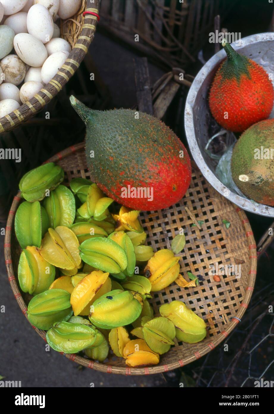 Vietnam: Sternfrüchte und Gac-Früchte zum Verkauf auf einem Markt in der Altstadt von Hanoi. Die Straßen der Hauptstadt Hanoi und vor allem die größte Stadt Ho Chi Minh City sind voller Begeisterung und geschäftlicher Energie. Die Aufgabe der sozialistischen Ökonomie und ihre allmähliche Ersetzung durch einen begrenzten marktorientierten Kapitalismus wurden von der Bevölkerung begrüßt. Überall wollen die Menschen Geld verdienen, und die Straßen sind voll von kleinen Privatunternehmen, die alle Arten von Gegenständen verkaufen. Stockfoto