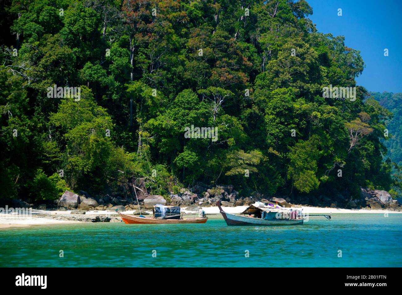 Thailand: Tourboote, Ko Surin Tai, Surin Islands Marine-Nationalpark. Ko Surin Marine National Park ist eine der letzten Grenzen Thailands zum Tauchen und Segeln. Dieser Meerespark in der Andamanensee beherbergt einige der am stärksten entwickelten Korallenriffe des Landes. Die Inselgruppe Koh Surin ist eine 135 km2 große Fläche in der Andamanensee, etwa 60 Kilometer (38 Meilen) vor der Provinz Ranong. Die fünf Inseln des Parks liegen südlich der Grenze zu Birma. Koh Surin Tai ist etwa 12 Quadratkilometer groß und 350 Meter am höchsten Punkt. Stockfoto