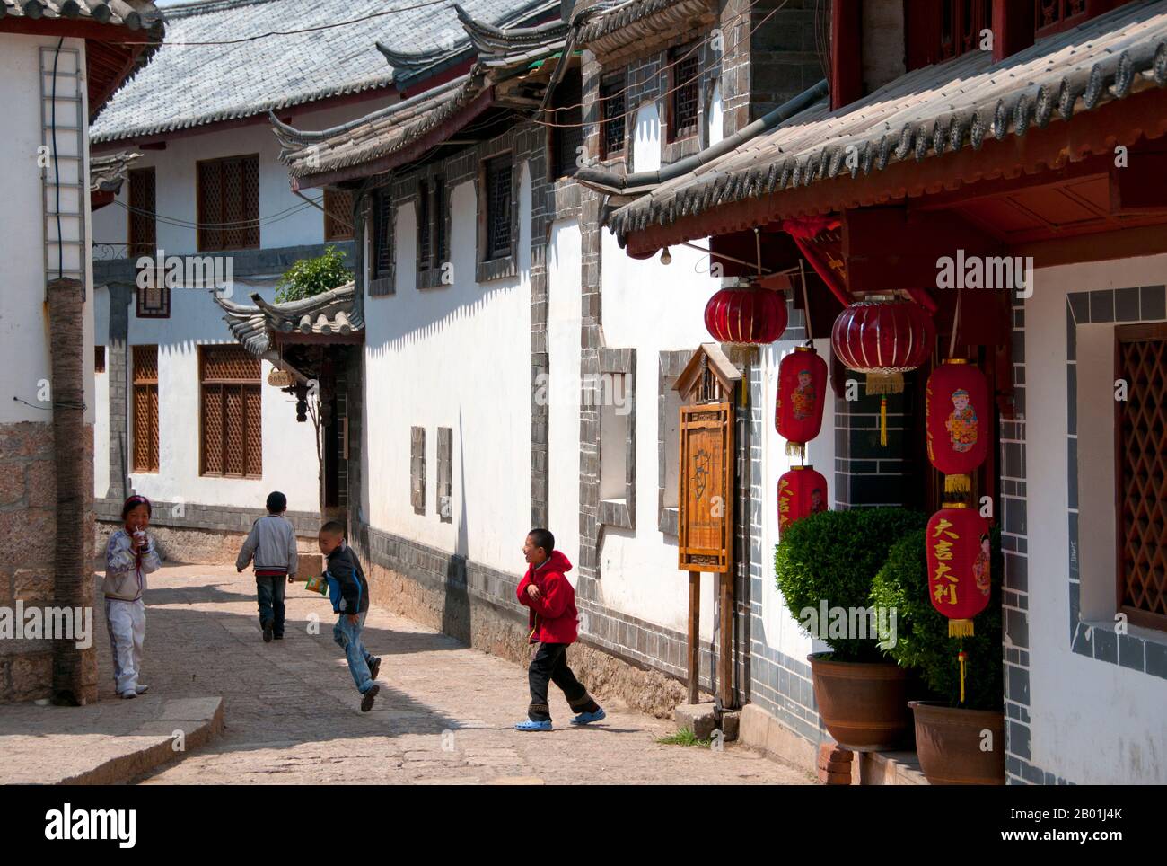China: Schulkinder in einer Hinterstraße der Altstadt von Lijiang, Provinz Yunnan. Die Naxi oder Nakhi sind eine ethnische Gruppe, die in den Ausläufern des Himalaya im Nordwesten der Provinz Yunnan und im Südwesten der Provinz Sichuan in China lebt. Man geht davon aus, dass die Naxi ursprünglich aus Tibet stammen und bis vor kurzem die Landhandelsverbindungen mit Lhasa und Indien aufrechterhalten haben. Die Naxi gehören zu den 56 ethnischen Gruppen, die von der Volksrepublik China offiziell anerkannt wurden. Die Naxi sind traditionell Anhänger der Dongba-Religion. Stockfoto