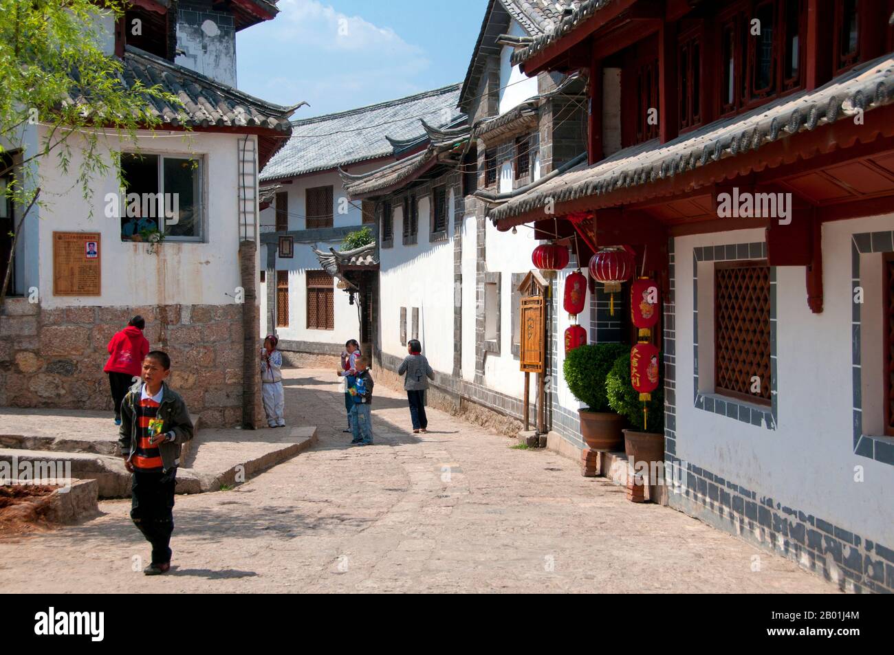 China: Schulkinder in einer Hinterstraße der Altstadt von Lijiang, Provinz Yunnan. Die Naxi oder Nakhi sind eine ethnische Gruppe, die in den Ausläufern des Himalaya im Nordwesten der Provinz Yunnan und im Südwesten der Provinz Sichuan in China lebt. Man geht davon aus, dass die Naxi ursprünglich aus Tibet stammen und bis vor kurzem die Landhandelsverbindungen mit Lhasa und Indien aufrechterhalten haben. Die Naxi gehören zu den 56 ethnischen Gruppen, die von der Volksrepublik China offiziell anerkannt wurden. Die Naxi sind traditionell Anhänger der Dongba-Religion. Stockfoto