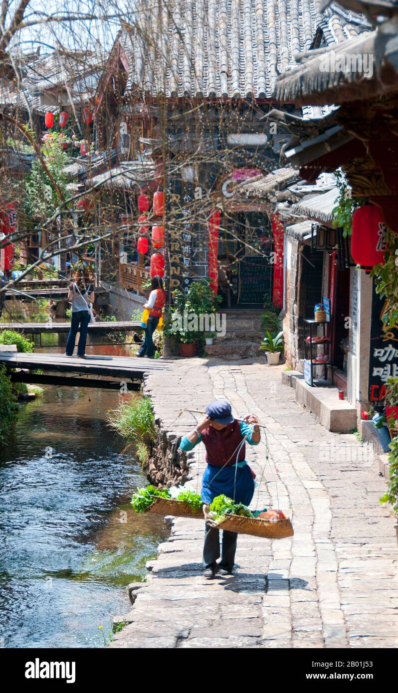 China: Hübsche Bäche verlaufen durch das Herz der Altstadt von Lijiang, Provinz Yunnan. Die Naxi oder Nakhi sind eine ethnische Gruppe, die in den Ausläufern des Himalaya im Nordwesten der Provinz Yunnan und im Südwesten der Provinz Sichuan in China lebt. Man geht davon aus, dass die Naxi ursprünglich aus Tibet stammen und bis vor kurzem die Landhandelsverbindungen mit Lhasa und Indien aufrechterhalten haben. Die Naxi gehören zu den 56 ethnischen Gruppen, die von der Volksrepublik China offiziell anerkannt wurden. Die Naxi sind traditionell Anhänger der Dongba-Religion. Stockfoto