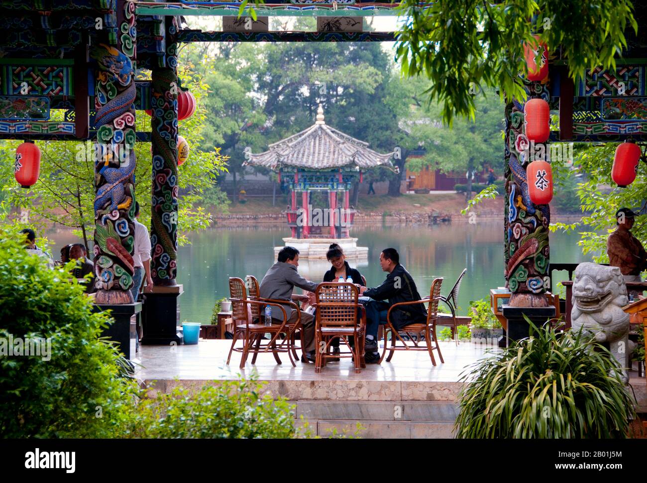 China: Kartenspielen in einem Teehaus im Black Dragon Pool Park, nördlich der Altstadt von Lijiang, Provinz Yunnan. Die Naxi oder Nakhi sind eine ethnische Gruppe, die in den Ausläufern des Himalaya im Nordwesten der Provinz Yunnan und im Südwesten der Provinz Sichuan in China lebt. Man geht davon aus, dass die Naxi ursprünglich aus Tibet stammen und bis vor kurzem die Landhandelsverbindungen mit Lhasa und Indien aufrechterhalten haben. Die Naxi gehören zu den 56 ethnischen Gruppen, die von der Volksrepublik China offiziell anerkannt wurden. Die Naxi sind traditionell Anhänger der Dongba-Religion. Stockfoto