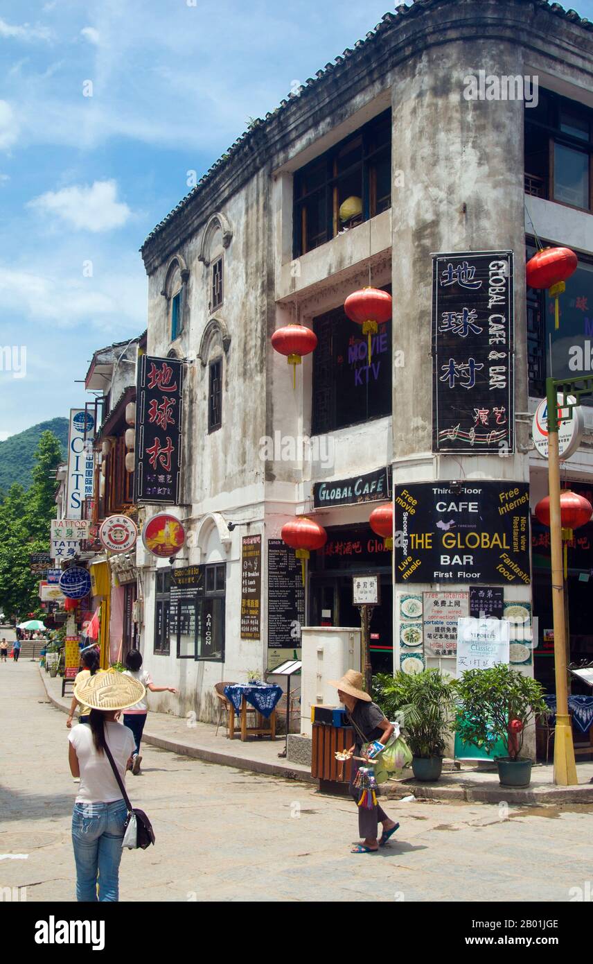 China: Touristen in Xi Jie („Foreigner Street“), Yangshuo, nahe Guilin, Provinz Guangxi. Yangshuo ist zu Recht berühmt für seine dramatische Landschaft. Es liegt am Westufer des Flusses Li (Lijiang) und ist nur 60 Kilometer stromabwärts von Guilin. In den letzten Jahren ist es zu einem beliebten Reiseziel bei Touristen geworden und hat gleichzeitig das Gefühl einer kleinen Flussstadt bewahrt. Guilin ist der Schauplatz von Chinas berühmtesten Landschaften und inspiriert Tausende von Gemälden über viele Jahrhunderte. Sie wurden oft als die „schönsten Berge und Flüsse unter dem Himmel“ bezeichnet. Stockfoto