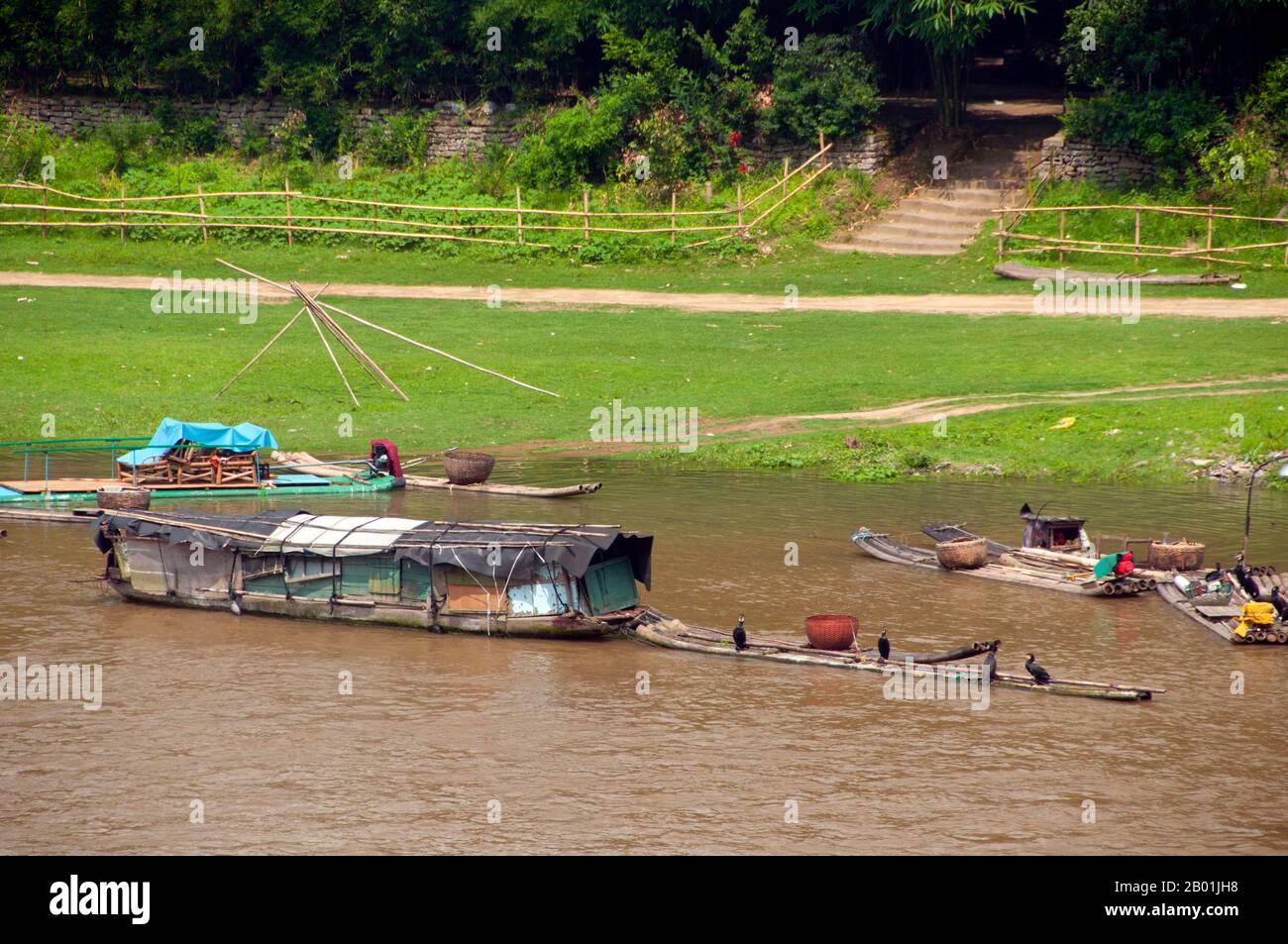 China: Kormorane und Fischerboote auf dem Li-Fluss in Yangshuo, nahe Guilin, Provinz Guangxi. Yangshuo ist zu Recht berühmt für seine dramatische Landschaft. Es liegt am Westufer des Flusses Li (Lijiang) und ist nur 60 Kilometer stromabwärts von Guilin. In den letzten Jahren ist es zu einem beliebten Reiseziel bei Touristen geworden und hat gleichzeitig das Gefühl einer kleinen Flussstadt bewahrt. Guilin ist der Schauplatz von Chinas berühmtesten Landschaften und inspiriert Tausende von Gemälden über viele Jahrhunderte. Sie wurden oft als die „schönsten Berge und Flüsse unter dem Himmel“ bezeichnet. Stockfoto