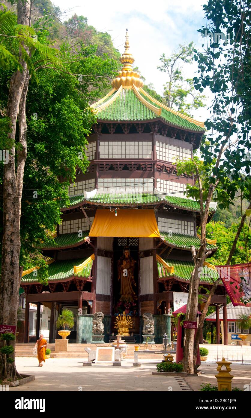 Thailand: Pagode mit Guan-Yin-Bild, Wat Tham Seua, Krabi-Stadt, Provinz Krabi, Südthailand. Wat Tham Seua, der „Tempel der Tigerhöhle“, ist in eine Höhle in einer Kalksteinklippe gebaut. Umgeben von einzelnen Mönchsresidenzen ist dies einer der bekanntesten Waldtempel im Süden Thailands. Der Hauptviharn oder die Montagehalle erstreckt sich in eine lange, flache Kalksteinhöhle, die verschiedene düstere Erinnerungen an die Sterblichkeit als Gegengewicht zu den weltlichen Wünschen zeigt. Hinter der Höhle führt eine Marmortreppe hinauf zur „Tigerhöhle“ selbst. Stockfoto