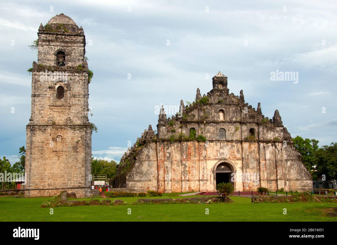 Philippinen: Glockenturm und Kirche mit ihren riesigen Stützen, San Agustin (St. Augustine) katholische Kirche, Paoay, Ilocos Norte, Luzon Island. Die früheste historische Erwähnung der Gegend von Paoay geht auf das Jahr 1593 zurück und wurde 1686 zu einer Augustiner-unabhängigen Pfarrei. Der Bau der heutigen Kirche wurde 1694 vom Augustiner Pfarrer Antonio Estavillo begonnen und 1710 fertiggestellt. Die Kirche ist berühmt für ihre eigenständige Architektur, die durch die riesigen Streben an den Seiten und auf der Rückseite des Gebäudes hervorgehoben wird. Stockfoto