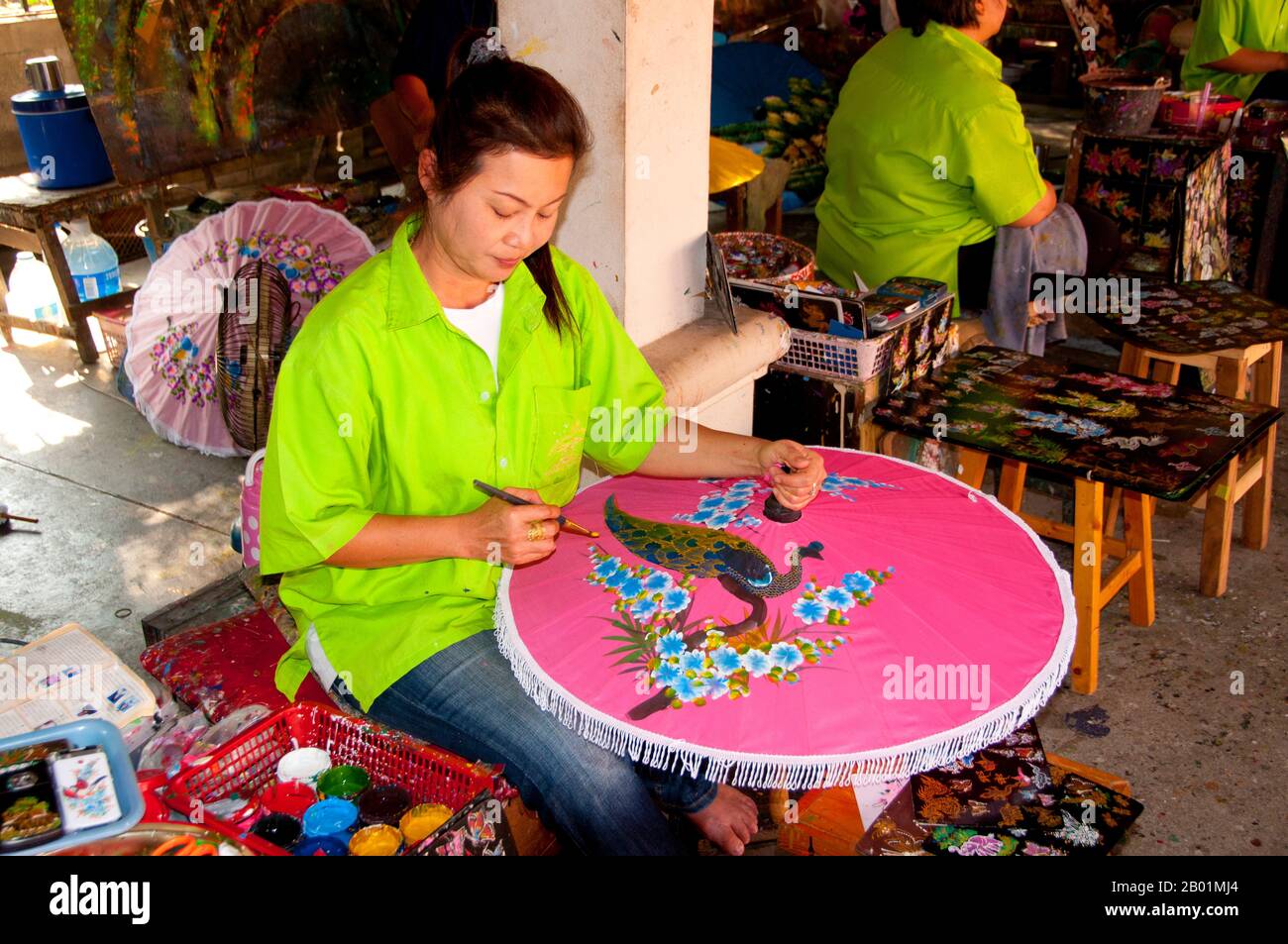 Thailand: Dekoration des Regenschirms, Bo Sang Umbrella Village, in der Nähe von Chiang Mai, Nordthailand. Bo Sang, in der Nähe der nordthailändischen Stadt Chiang Mai, ist berühmt für seine handgefertigten farbenfrohen Regenschirme und Sonnenschirme. Einmal im Jahr, Ende Januar, findet in der Stadt das Bo Sang Umbrella and San Kamphaeng Handwerksfestival statt. Chiang Mai (bedeutet „neue Stadt“), manchmal als „Chiengmai“ oder „Chiangmai“ geschrieben, ist die größte und kulturell bedeutendste Stadt im Norden Thailands. König Mengrai gründete 1296 die Stadt Chiang Mai und folgte Chiang Rai als Hauptstadt an. Stockfoto