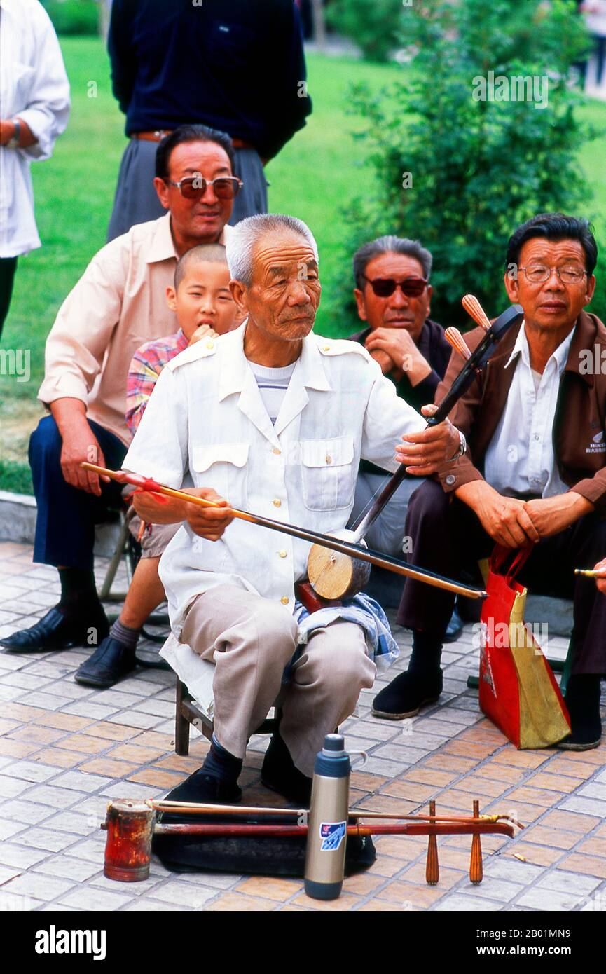 China: Ein Mann spielt einen Banhu in einem Park in Wuwei, Provinz Gansu. Die Stadt Wuwei hat eine Bevölkerung von etwa 500.000, hauptsächlich Han-Chinesen, aber mit sichtbaren Zahlen von Hui sowie Mongolen und Tibetern. Früher hieß es Liangzhou. Er dominiert das östliche Ende des Hexi-Korridors und spielt seit langem eine wichtige Rolle auf dieser wichtigen Handelsroute. WuWeis berühmtestes historisches Artefakt, das gefeierte Bronzepferd der Han-Dynastie (206 v. Chr. - 220 n. Chr.), bekannt als das fliegende Pferd von Gansu, wurde hier in einem Grab unter dem Leitai-Tempel (Leitai Si) im nördlichen Teil der Stadt entdeckt. Stockfoto