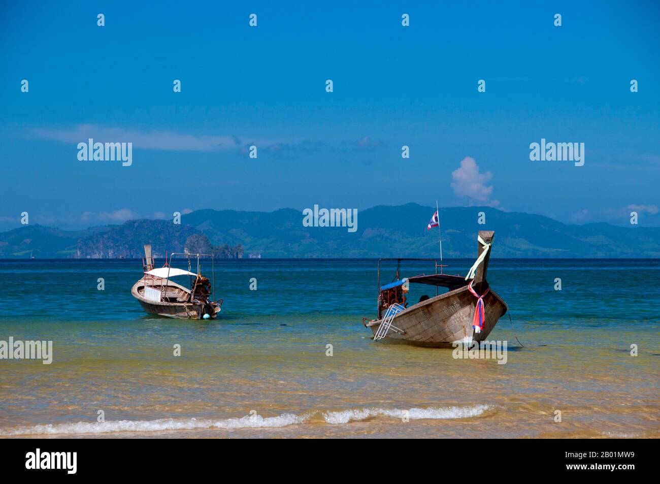 Thailand: Ausflugsboote, hat Khlong Muang, Krabi Küste. Hat Khlong Muang liegt westlich von hat Noppharat Thara und ist von Ao Nang durch eine lange, felsige Landzunge geschützt. Der Strand blickt nach Westen über die Andamanensee in Richtung Ko Phi Phi. Die Provinz Krabi besteht aus mehr als 5.000 Quadratkilometern mit Dschungel bedeckten Hügeln und scharfen, zerklüfteten Karstvorsprüngen sowie mehr als 100 km üppiger, unberührter Küste und rund 200 Inseln in der benachbarten Andamanensee. Etwa 40 Prozent der Provinzbevölkerung sind muslimisch, der Rest überwiegend buddhistisch. Stockfoto