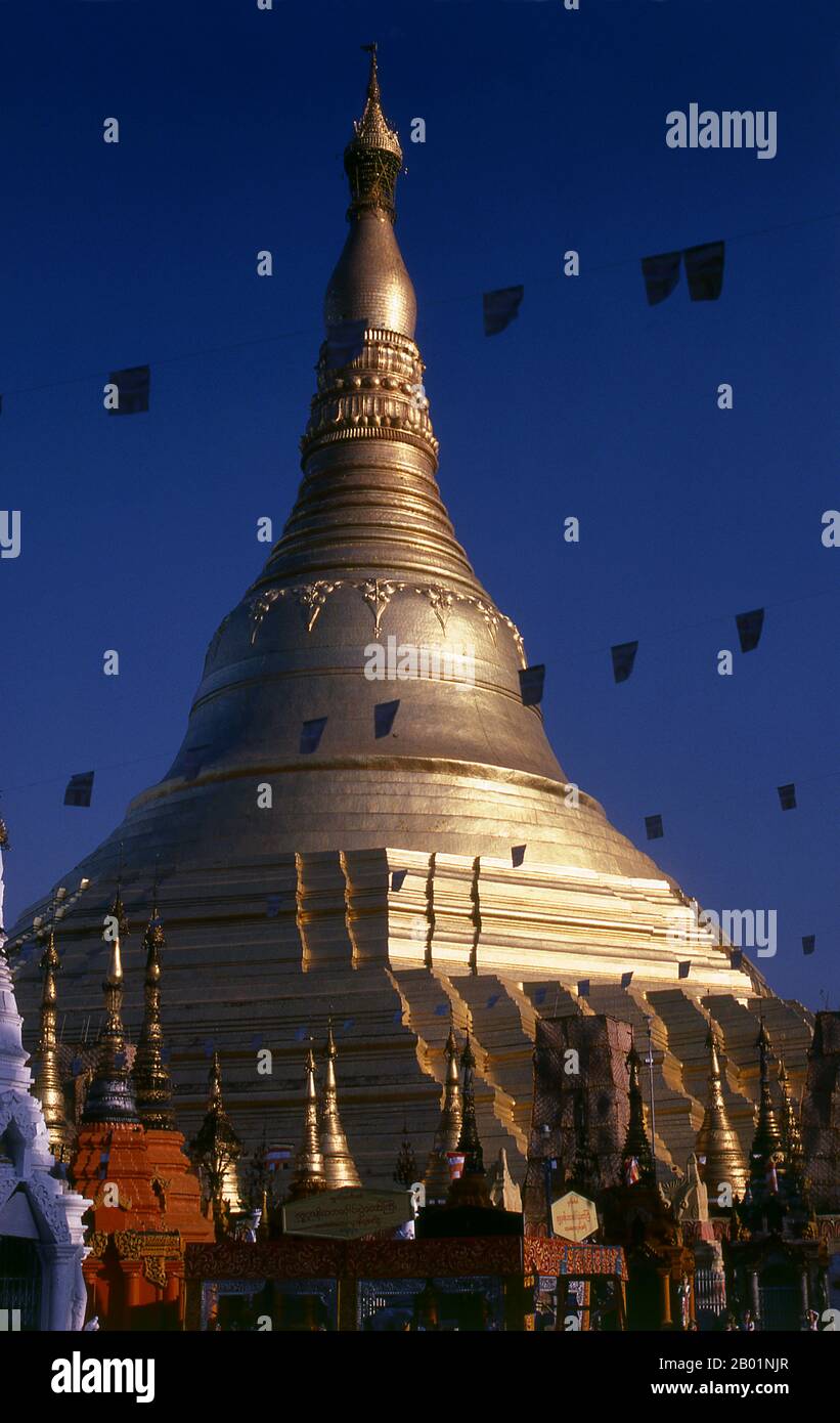 Birma/Myanmar: Shwedagon-Pagode, Yangon (Rangun). Die goldene Stupa der Shwedagon-Pagode erhebt sich fast 100 m (330 ft) über ihrer Lage auf dem Singuttara Hill und ist mit 8.688 massiven Goldplatten überzogen. Diese zentrale Stupa ist von mehr als 100 anderen Gebäuden umgeben, darunter kleinere Stupas und Pavillons. Die Pagode war bereits gut etabliert, als Bagan Burma im 11. Jahrhundert dominierte. Königin Shinsawbu, die im 15. Jahrhundert regierte, soll der Pagode ihre heutige Form gegeben haben. Sie baute auch die Terrassen und Mauern um die Stupa herum. Stockfoto