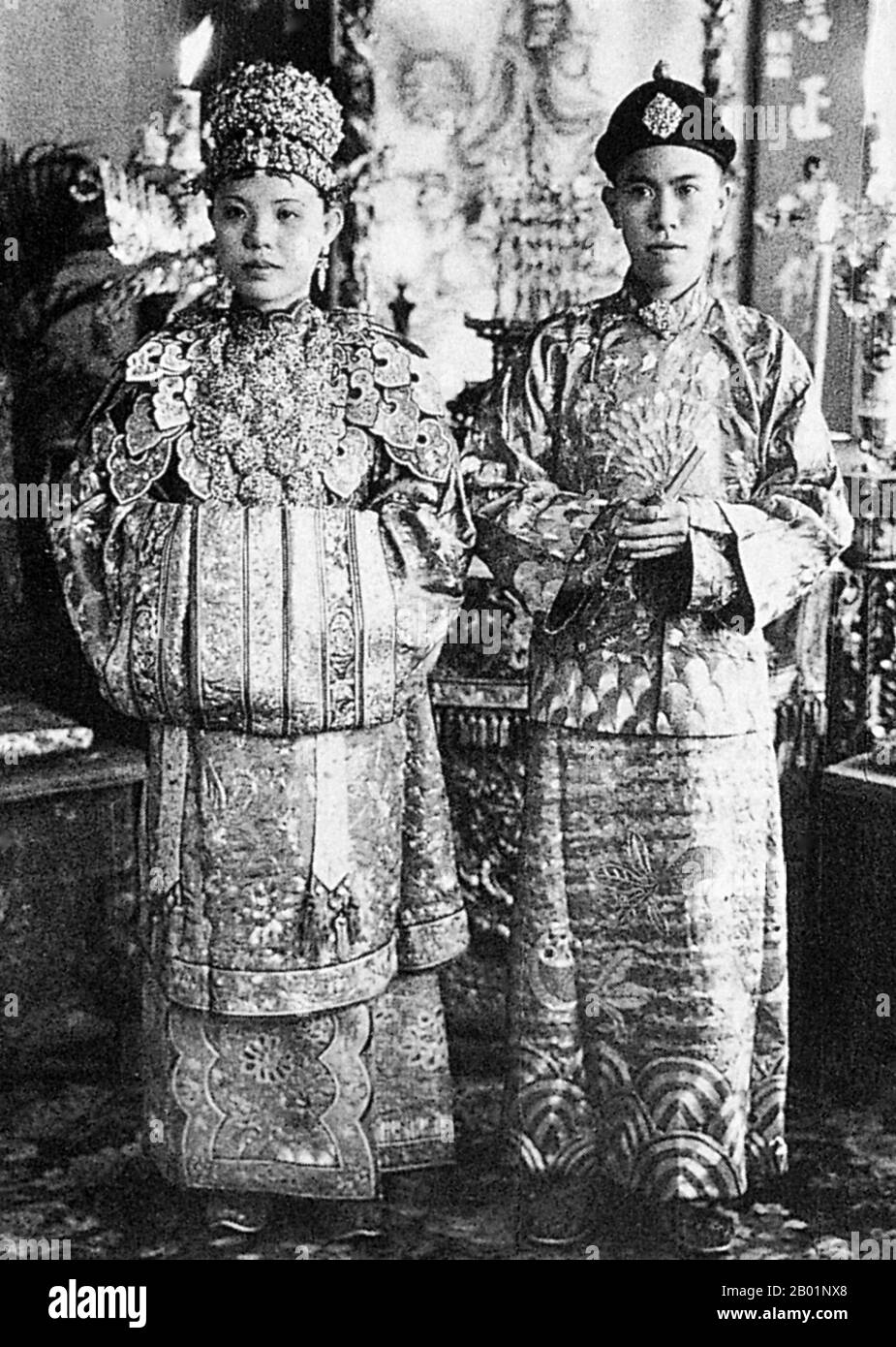 Malaysia/Singapur: Eine Peranakan Braut und Bräutigam, Melaka (Malakka), Anfang des 20. Jahrhunderts. Peranakan Chinese und Baba-Nyonya sind die Bezeichnungen für die Nachkommen chinesischer Einwanderer aus dem späten 15. Und 16. Jahrhundert, die während der Kolonialzeit in den malaiisch-indonesischen Archipel von Nusantara kamen. Mitglieder dieser Gemeinde in Malaysia bezeichnen sich als „Nyonya-Baba“ oder „Baba-Nyonya“. Nyonya ist der Begriff für die Weibchen und Baba für die Männchen. Sie gilt insbesondere für die ethnischen chinesischen Bevölkerungsgruppen der British Straits Settlements in Malaya und der von den Niederlanden kontrollierten Insel Java und anderen Orten. Stockfoto