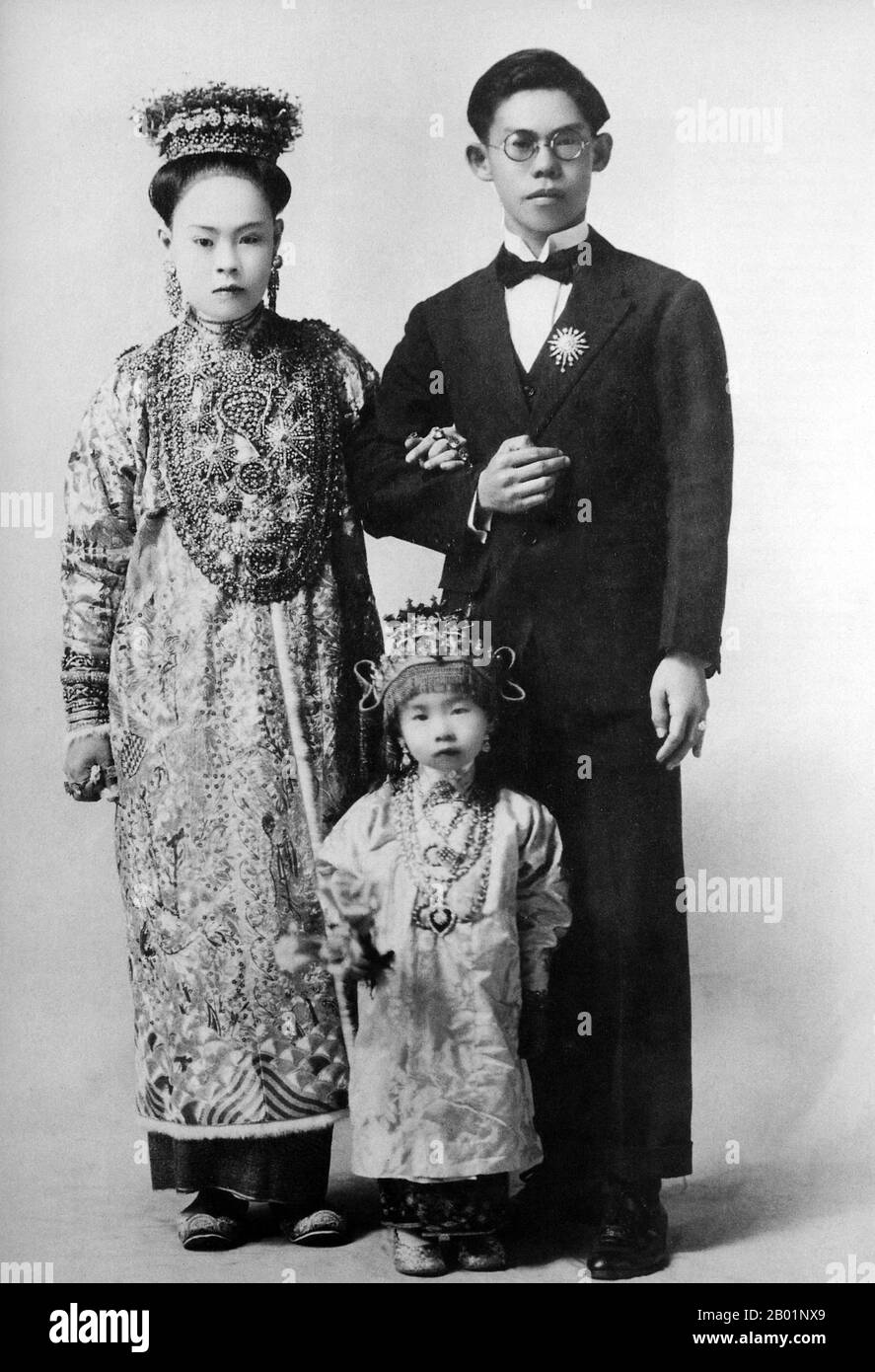 Malaysia/Singapur: Eine Peranakan Braut und Bräutigam mit der winzigen Brautjungfer Penang, Anfang des 20. Jahrhunderts. Peranakan Chinese und Baba-Nyonya sind die Bezeichnungen für die Nachkommen chinesischer Einwanderer aus dem späten 15. Und 16. Jahrhundert, die während der Kolonialzeit in den malaiisch-indonesischen Archipel von Nusantara kamen. Mitglieder dieser Gemeinde in Malaysia bezeichnen sich als „Nyonya-Baba“ oder „Baba-Nyonya“. Nyonya ist der Begriff für die Weibchen und Baba für die Männchen. Sie gilt insbesondere für die ethnischen chinesischen Bevölkerungsgruppen der British Straits Settlements in Malaya und der von den Niederlanden kontrollierten Insel Java und anderen Orten Stockfoto