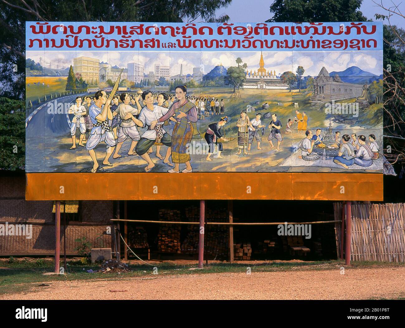 Laos: Politisches Plakat im Stil des revolutionären Sozialistischen Realismus auf den Straßen von Vientiane. Sozialistischer Realismus ist ein Stil realistischer Kunst, der in der Sowjetunion entwickelt wurde und in anderen kommunistischen Ländern zu einem dominanten Stil wurde. Der sozialistische Realismus ist ein teleologisch orientierter Stil, der die Ziele des Sozialismus und Kommunismus fördern soll. Obwohl verwandt, sollte sie nicht mit dem sozialen Realismus verwechselt werden, einer Art Kunst, die Themen von sozialem Interesse realistisch darstellt. Im Gegensatz zum sozialen Realismus verherrlicht der sozialistische Realismus oft die Rolle der Armen. Stockfoto