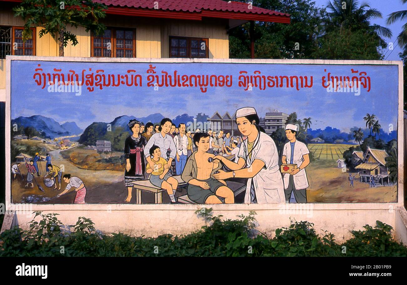 Laos: Gesundheitsfürsorge, politisches Poster im revolutionären sozialistischen Realismus auf den Straßen von Vientiane. Der sozialistische Realismus ist ein Stil realistischer Kunst, der in der Sowjetunion entwickelt wurde und in anderen kommunistischen Ländern zu einem dominierenden Stil wurde. Der sozialistische Realismus ist ein teleologisch orientierter Stil, dessen Ziel die Förderung der Ziele des Sozialismus und des Kommunismus ist. Obwohl sie damit verbunden ist, darf sie nicht mit dem sozialen Realismus verwechselt werden, einer Art von Kunst, die Themen sozialer Belange realistisch darstellt. Anders als der soziale Realismus verherrlicht der sozialistische Realismus oft die Rolle der Armen. Stockfoto