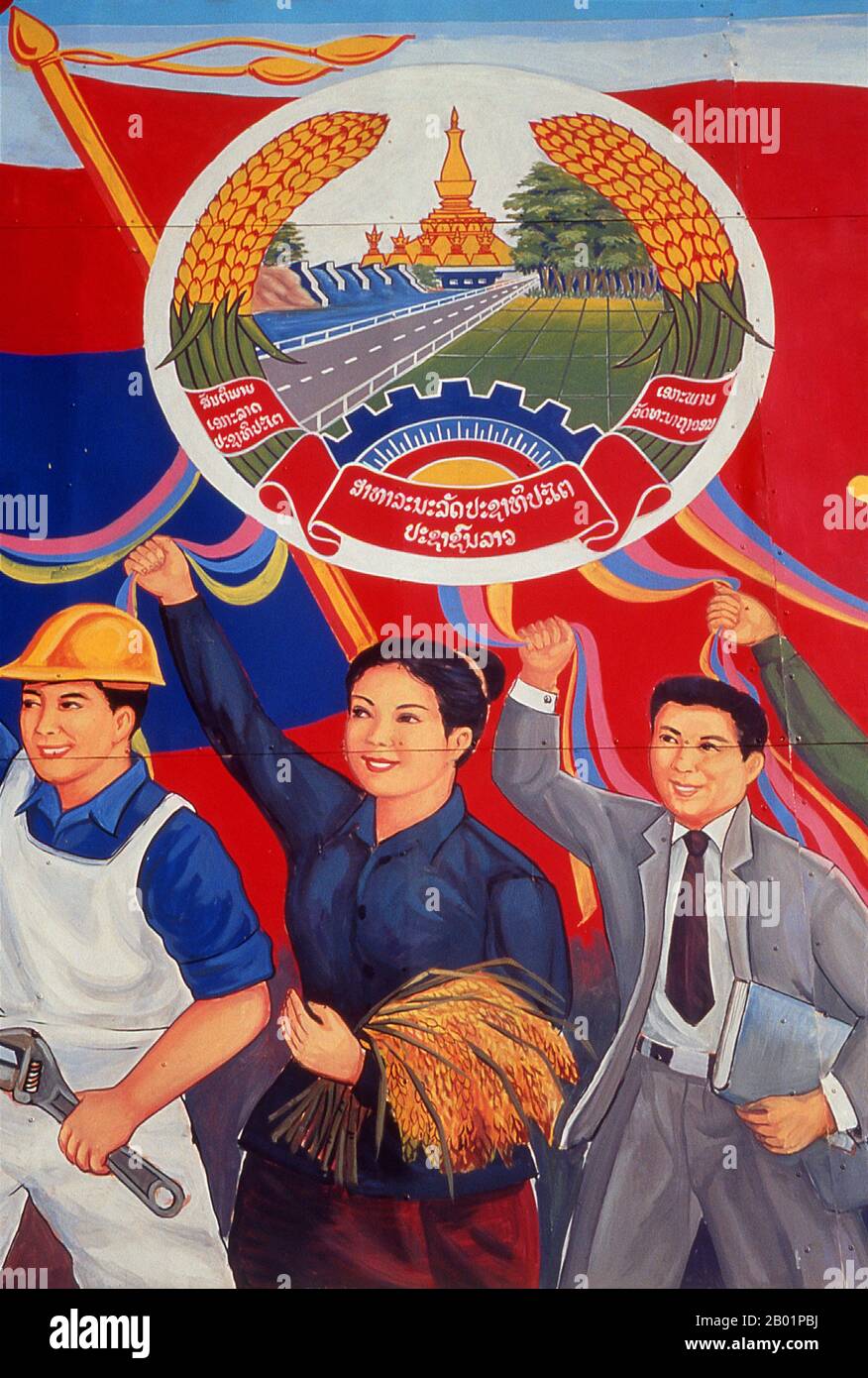 Laos: Politisches Plakat im Stil des revolutionären Sozialistischen Realismus auf den Straßen von Vientiane. Sozialistischer Realismus ist ein Stil realistischer Kunst, der in der Sowjetunion entwickelt wurde und in anderen kommunistischen Ländern zu einem dominanten Stil wurde. Der sozialistische Realismus ist ein teleologisch orientierter Stil, der die Ziele des Sozialismus und Kommunismus fördern soll. Obwohl verwandt, sollte sie nicht mit dem sozialen Realismus verwechselt werden, einer Art Kunst, die Themen von sozialem Interesse realistisch darstellt. Im Gegensatz zum sozialen Realismus verherrlicht der sozialistische Realismus oft die Rolle der Armen. Stockfoto