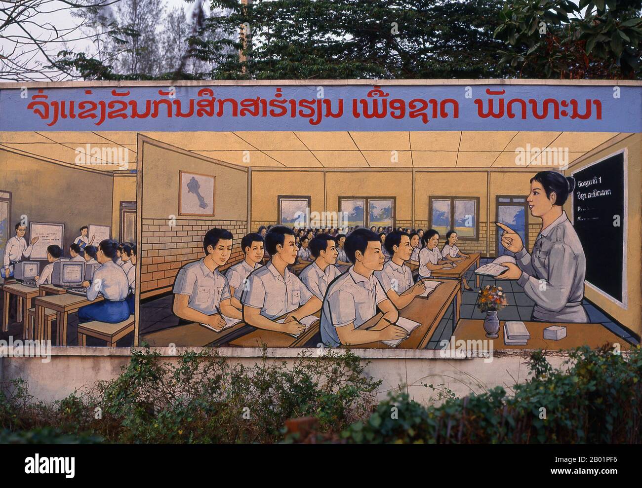 Laos: Bildung, politisches Poster im revolutionären sozialistischen Realismus auf den Straßen von Vientiane. Der sozialistische Realismus ist ein Stil realistischer Kunst, der in der Sowjetunion entwickelt wurde und in anderen kommunistischen Ländern zu einem dominierenden Stil wurde. Der sozialistische Realismus ist ein teleologisch orientierter Stil, dessen Ziel die Förderung der Ziele des Sozialismus und des Kommunismus ist. Obwohl sie damit verbunden ist, darf sie nicht mit dem sozialen Realismus verwechselt werden, einer Art von Kunst, die Themen sozialer Belange realistisch darstellt. Anders als der soziale Realismus verherrlicht der sozialistische Realismus oft die Rolle der Armen. Stockfoto