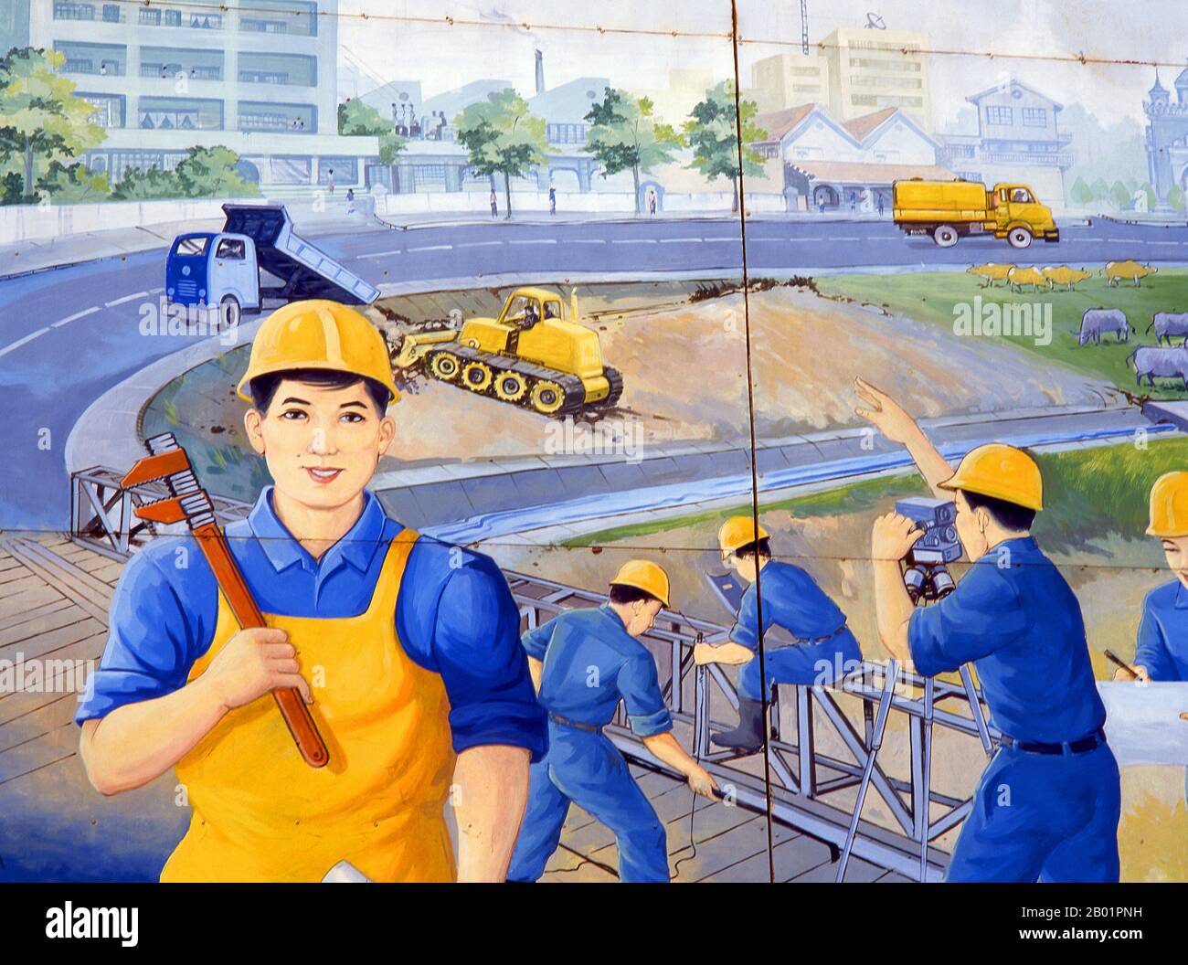 Laos: Construction, politisches Poster im Stil der Revolutionären Sozialisten auf den Straßen von Vientiane. Der sozialistische Realismus ist ein Stil realistischer Kunst, der in der Sowjetunion entwickelt wurde und in anderen kommunistischen Ländern zu einem dominierenden Stil wurde. Der sozialistische Realismus ist ein teleologisch orientierter Stil, dessen Ziel die Förderung der Ziele des Sozialismus und des Kommunismus ist. Obwohl sie damit verbunden ist, darf sie nicht mit dem sozialen Realismus verwechselt werden, einer Art von Kunst, die Themen sozialer Belange realistisch darstellt. Anders als der soziale Realismus verherrlicht der sozialistische Realismus oft die Rolle der Armen. Stockfoto