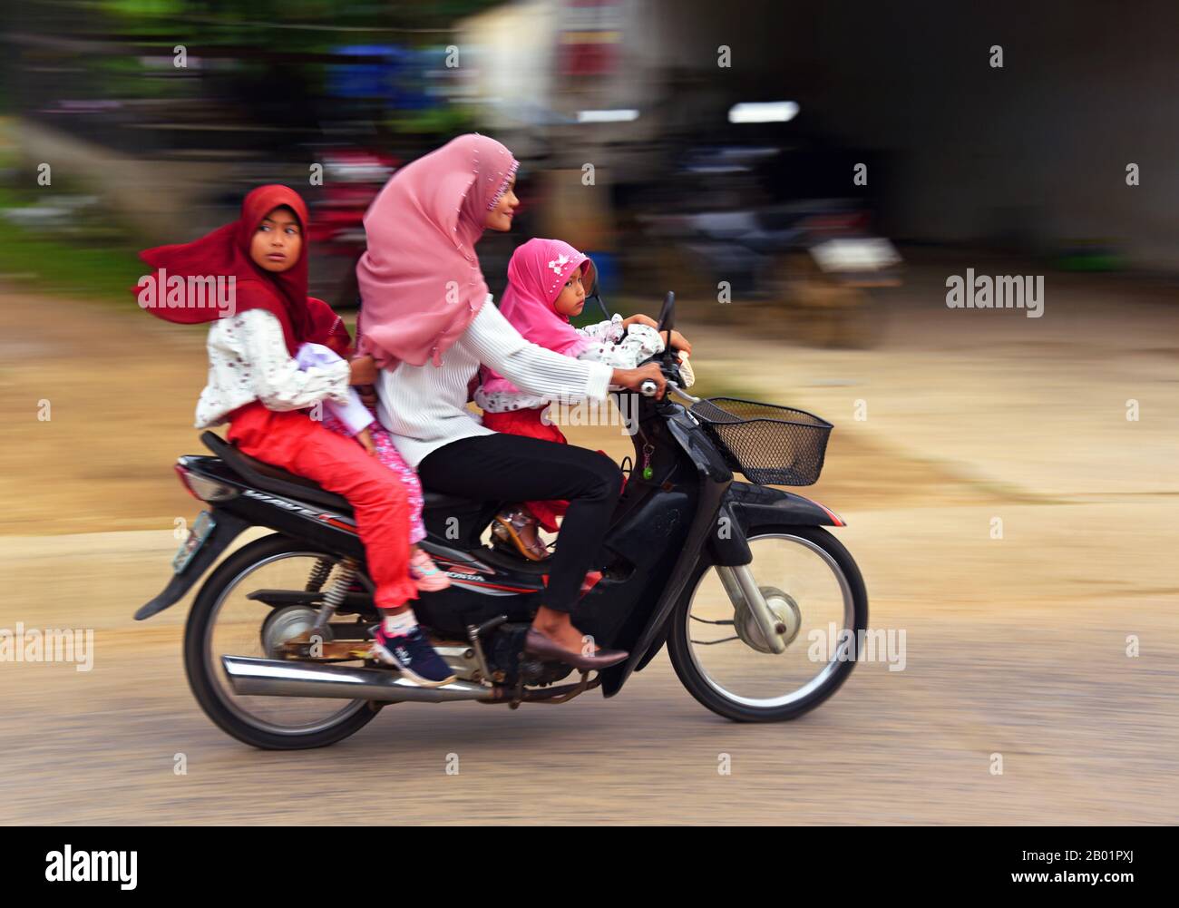 Mutter, die mit ihren drei Kindern ein Motorrad fährt, Thailand, Kho Yoa Noi Stockfoto