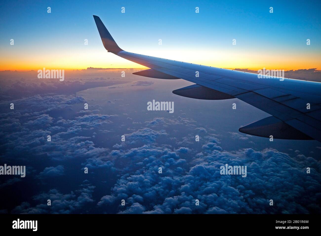 Blick aus dem Fenster eines Flugzeugs zum Sonnenaufgang über den Wolken, Spanien, Balearen, Mallorca Stockfoto