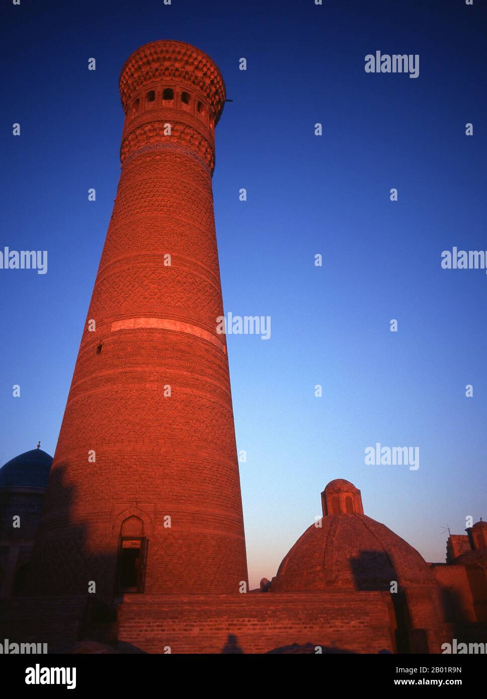 Usbekistan: Das Kalyan/Kalon Minaret, auch bekannt als das „Minaret des Todes“ bei Sonnenuntergang, Buchara. Das kalyanische Minarett oder Minâra-i Kalân (pesianisch/tadschikisch für das „große Minarett“) ist Teil des Po-i-Kalyan-Moschee-Komplexes und wurde von Bako entworfen und 1127 vom arachanidischen Herrscher Arslan Khan erbaut. Das Minarett ist in Form eines runden, nach oben verengenden Ziegelturms mit einem Durchmesser von 9 m (30 ft) unten, 6 m (20 ft) oben und einer Höhe von 46 m (150 ft) gefertigt. Das Minarett ist auch als „Turm des Todes“ bekannt, da jahrhundertelang Verbrecher hingerichtet wurden, indem sie von der Spitze geworfen wurden. Stockfoto