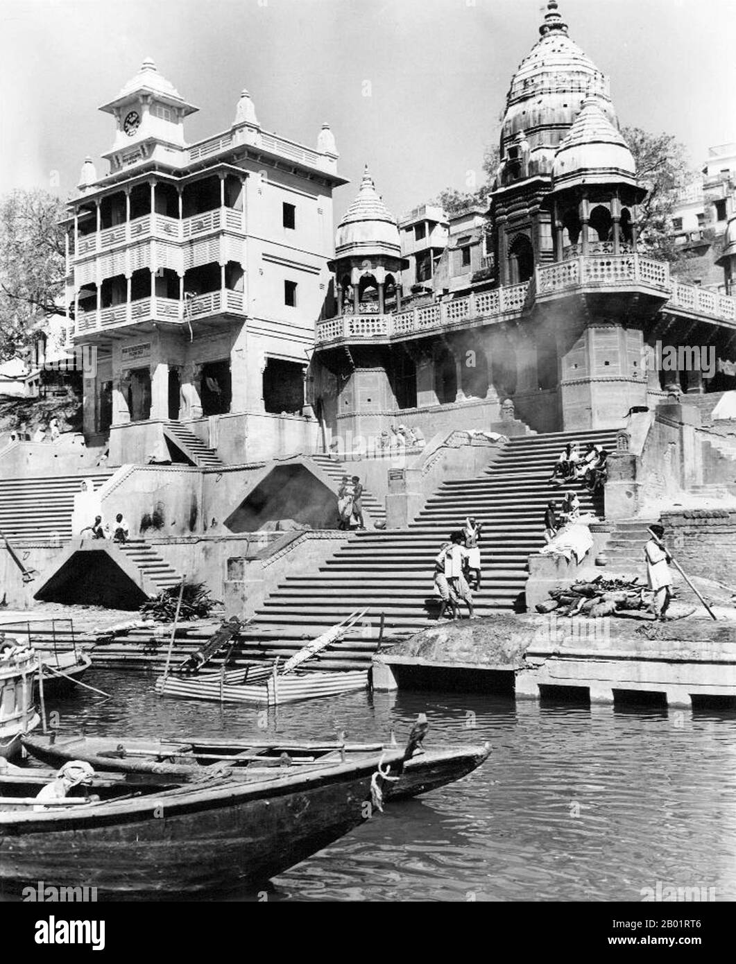 Indien: Manikarnika Ghat, Varanasi (Benares) um 1952. Varanasi, auch bekannt als Banaras oder Benaras, ist eine Stadt am Ufer des Ganges im indischen Bundesstaat Uttar Pradesh, 320 Kilometer (199 mi) südöstlich der Hauptstadt Lucknow. Die Stadt wird von Hindus, Buddhisten und Jains als heilige Stadt angesehen. Es ist eine der ältesten durchgehend bewohnten Städte der Welt und die älteste in Indien. Der Kaschi Naresh (Maharaja von Kaschi) ist der wichtigste Kulturförderer von Varanasi und ein wesentlicher Bestandteil aller religiösen Feiern. Stockfoto