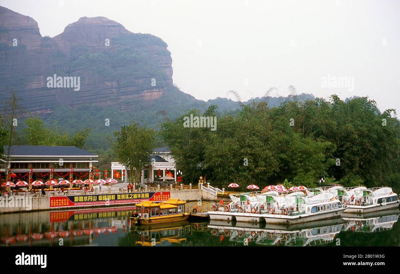 China: Fluss Jin am Eingang zu Danxiashan (Mount Danxia), nördlich von Shaoguan, Provinz Guangdong. Der Danxia Mountain, was Red Rosy Clouds Mountain bedeutet, ist eine berühmte malerische Gegend in der Nähe der Stadt Shaoguan im nördlichen Teil der Provinz Guangdong. Das Gebiet besteht aus einem rötlichen Sandstein, der im Laufe der Zeit zu einer Reihe von Bergen erodiert wurde, umgeben von kurvigen Klippen und vielen ungewöhnlichen Felsformationen (Danxia Landform). Es gibt eine Reihe von Tempeln in den Bergen und viele schöne Spaziergänge. Es gibt auch einen Fluss, der sich durch die Berge schlängelt, auf dem Bootsausflüge gemacht werden können. Stockfoto