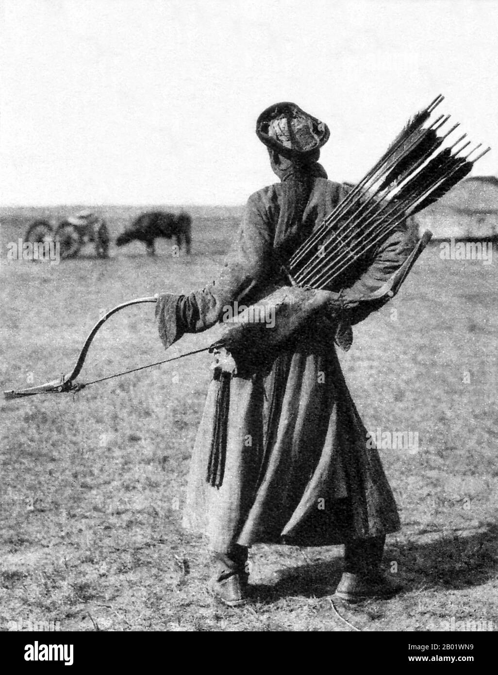 China/Innere Mongolei: Ein traditioneller mongolischer Bogenschütze im Innern Mongolischen Grasland, um 1940. Rückansicht. Der mongolische Bogen ist ein wiederkehrender Verbundbogen, der für seine militärische Wirksamkeit bekannt ist. Die alten mongolischen Bögen, die während der Zeit von Dschingis Khan verwendet wurden, waren kleiner als die modernen Waffen, die heute auf den meisten Naadam-Festivals verwendet wurden. Moderne mongolische Bögen sind größer und haben Schnur-Brücken. Das moderne Design ähnelt sehr den mandschurischen Bögen, die das chinesische Militär während der Qing-Dynastie verwendet hat. Antike und moderne mongolische Bögen sind Teil der asiatischen Tradition von Verbundbögen. Stockfoto