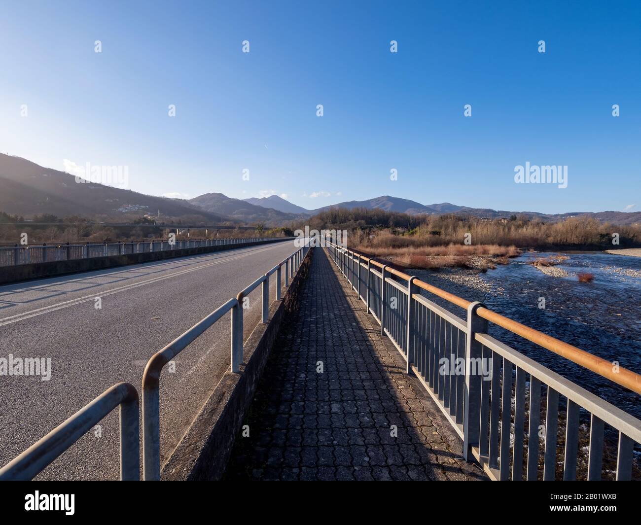 Fluchtpunkt auf der Brücke über den Fluss Magra in Lunigyana, in der Nähe von Aulla. Winterlandschaft. Nordtoskanisch. Stockfoto
