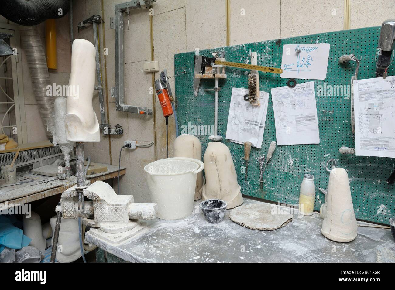 In der Prothesenwerkstatt. Holzrohlinge, Tischhalter, Töpfe und Werkzeuge auf einem Arbeitstisch zur Herstellung künstlicher Gliedmaßen Stockfoto