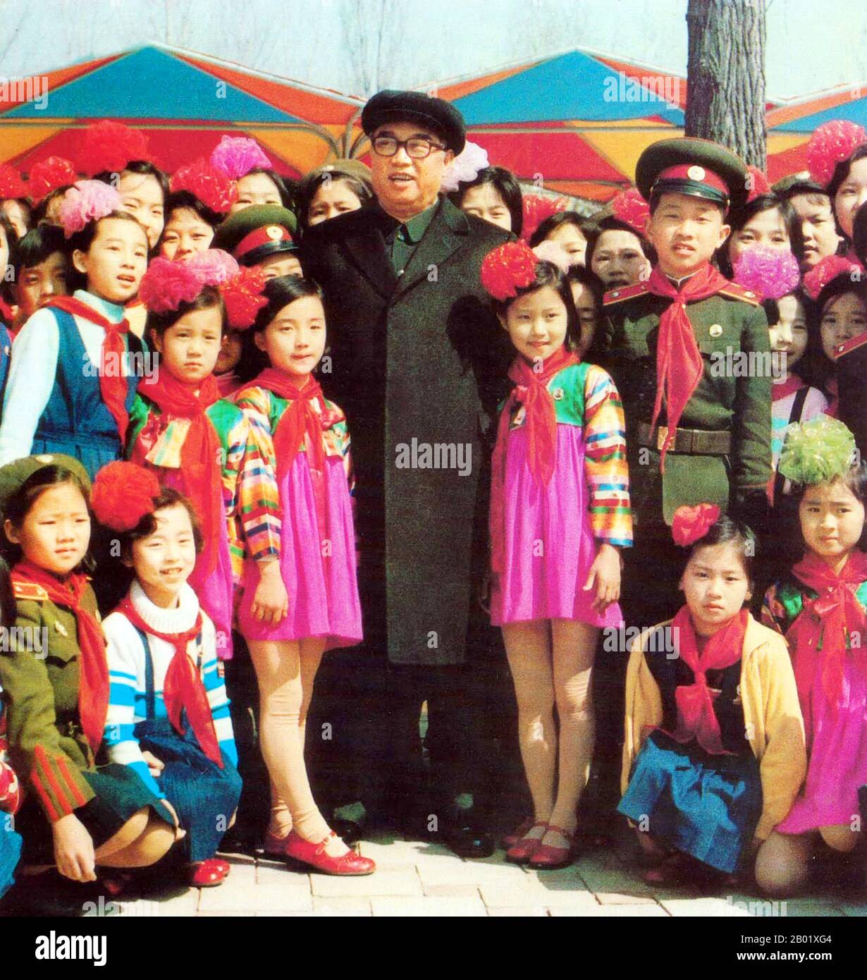Korea: Nordkoreas 'großer Führer' Kim Il Sung (15. April 1912 bis 8. Juli 1994), oberster Herrscher der Demokratischen Republik Korea (DVRK), posierte mit einer Gruppe von Kindern auf der Mangyongdae Fun Fair, 1982. Kim Il-sung war ein koreanischer kommunistischer Politiker, der Nordkorea, offiziell die Demokratische Volksrepublik Korea, von seiner Gründung 1948 bis zu seinem Tod 1994 regierte. Von 1948 bis 1972 war er Premierminister und von 1972 bis zu seinem Tod Präsident. Von 1949 bis 1994 war er Vorsitzender der Arbeiterpartei Koreas (von 1949 bis 1966 Vorsitzender). Stockfoto