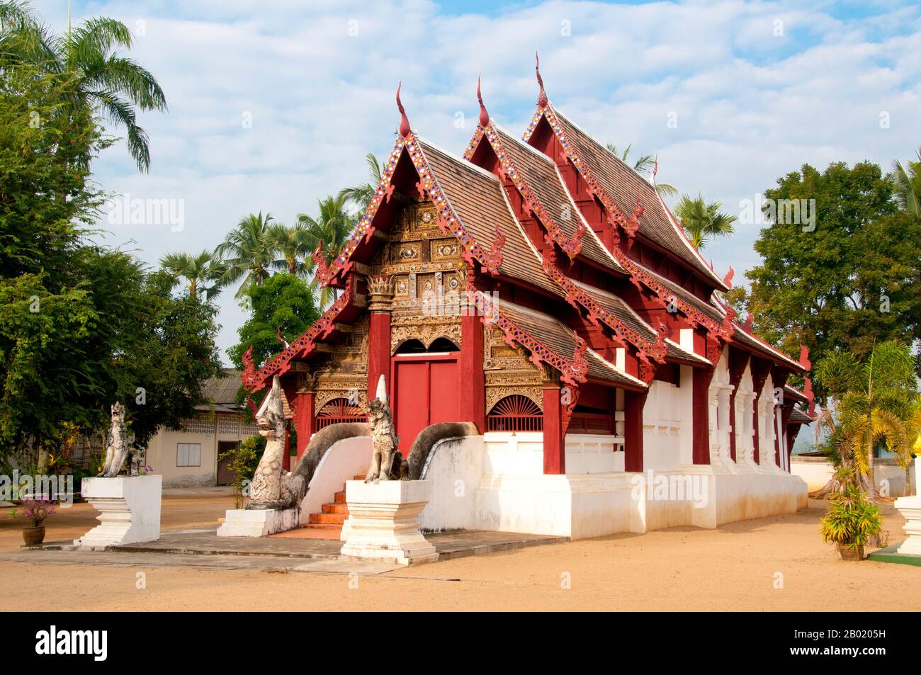 Wat Hang Dong วัด หางดง ist ein typisches Beispiel für die traditionelle Lan Na Tempelarchitektur. Der alte Viharn an diesem Tempel ist etwas aufwendiger als sein Gegenstück am nahe gelegenen Wat Ton Kwen, ähnelt aber im Wesentlichen Form, Stil und Aussehen. Auch dunkel und intim, mit einem niedrigen, geschwungenen, dreifach gestuften Dach, beherbergt der Viharn eine Sammlung von Buddha-Bildern, von denen mindestens zwei - rechts und links vom Hauptbild des Buddha - stilvoll und doch irgendwie seltsam primitiv sind. Der alte Viharn am Wat Hang Dong wurde nun schön restauriert, und auch ein neuer Ubosot hat es Stockfoto