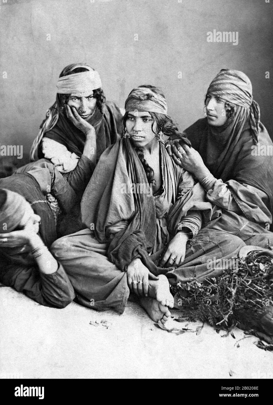 Syrien: Beduinenfrauen aus der syrischen Wüste. Foto von Tancrède R. Dumas (1830-1905), 1889. Beduinen sind Teil einer überwiegend in der Wüste lebenden arabischen ethnischen Gruppe, die traditionell in Stämme oder Clans unterteilt ist, die auf Arabisch als ʿašāʾir bekannt sind. Der Begriff Beduin leitet sich von einer Pluralform des arabischen Wortes badawī ab, wie es in umgangssprachlichen Dialekten ausgesprochen wird. Der arabische Begriff badawī leitet sich vom Wort bādiyah ab, was semiaride Wüste bedeutet (im Gegensatz zu ṣaḥarāʾ, was Wüste bedeutet). Ab dem späten 19. Jahrhundert begannen viele Beduinen unter britischer Herrschaft in ein seminomadisches Leben zu übergehen. Stockfoto