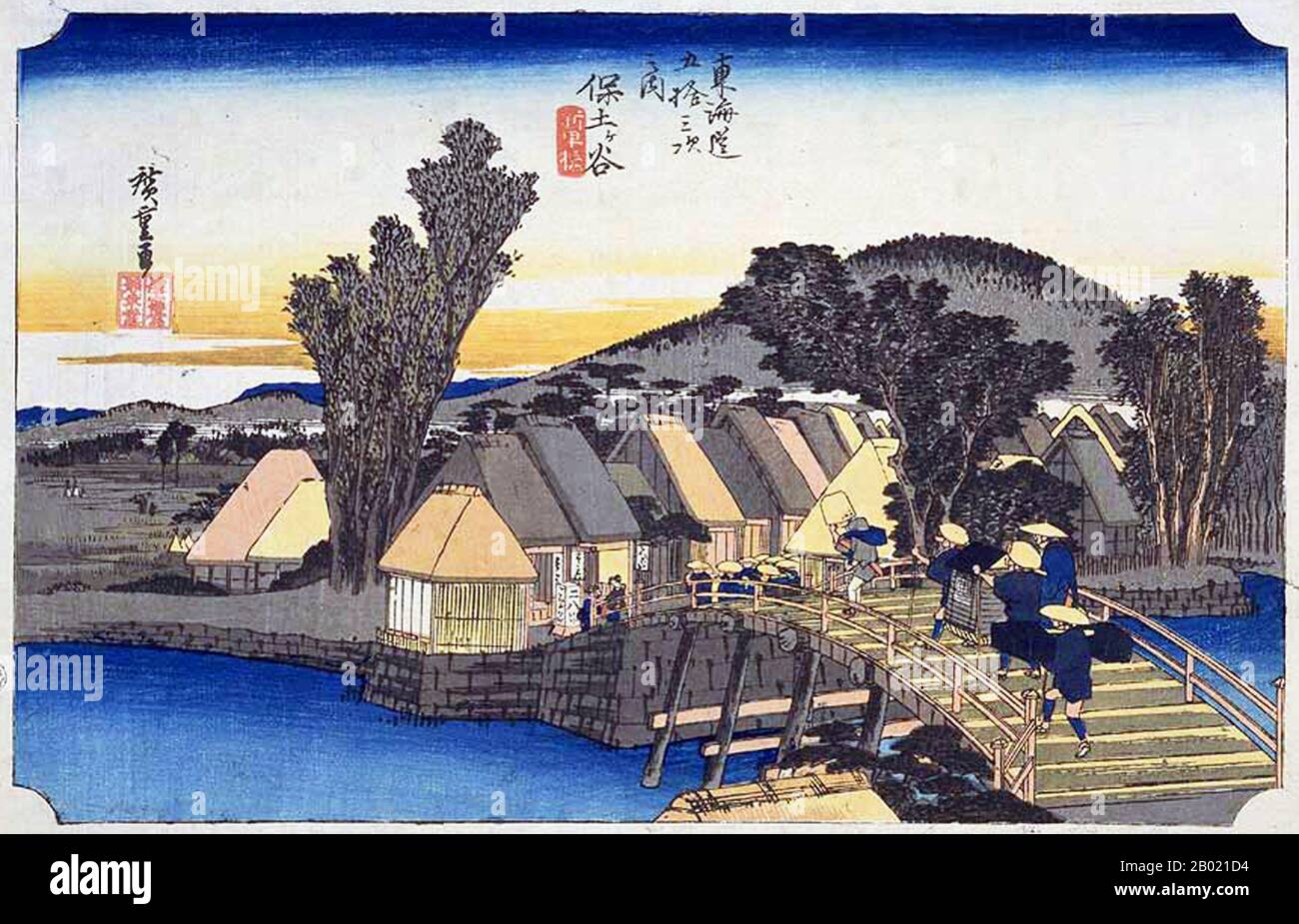 Japan: Station 4: Hodogaya Station und Shinkame Bridge. Ukiyo-e-Holzschnitt aus der Serie „Three Stations of the Tôkaidô Road“ von Utagawa Hiroshige (1797-1858), um 1834. Hodogaya: Eine Brücke über einen Bach, über den zwei Kolien ein geschlossenes Kago in Richtung eines Dorfes auf der gegenüberliegenden Uferseite tragen; hinter dem Dorf erhebt sich ein niedriger hölzerner Hügel. An dieser Landstation hatten die Reisenden eine Entfernung von 34 km von Edo zurückgelegt und waren gut in Reisestimmung. An der Brücke steht ein Restaurant, das Soba (Buchweizennudeln) serviert, mit Kellnerinnen, die Reisende einladen. Stockfoto