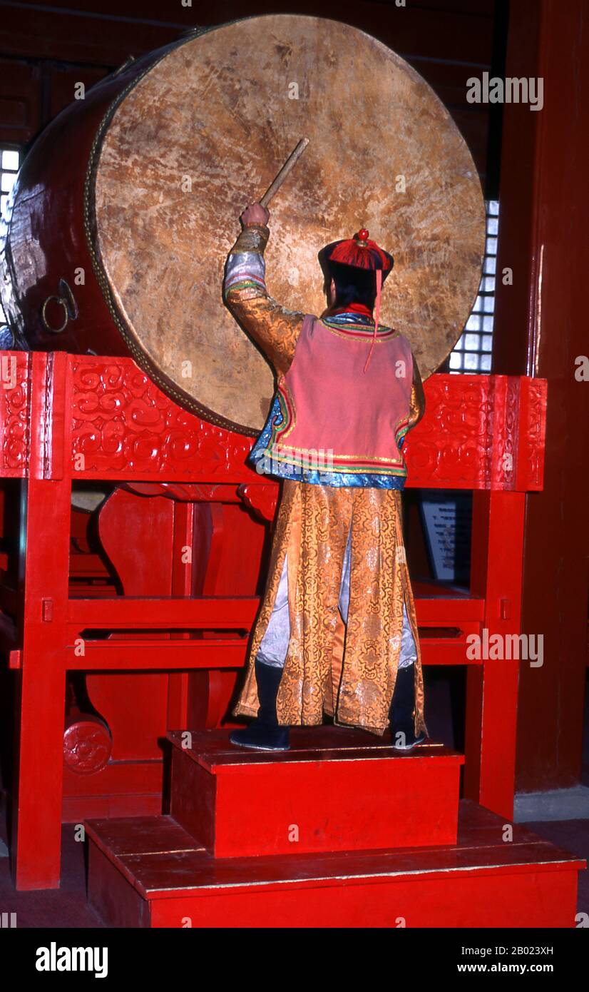 China: Zeremonieller Schlagzeuger im Trommelturm (Gulou), Peking. Der Trommelturm (Gǔlóu) und der Glockenturm (Zhōnglóu) wurden 1272 während der Regierungszeit von Kublai Khan (R. 1260–1294) errichtet. Kaiser Yongle (R. 1402–1424) baute die Türme 1420 wieder auf und sie wurden während der Regierungszeit des Qing-Kaisers Jiaqing (R. 1796–1820) wieder renoviert. Sowohl der Drum- als auch der Glockenturm wurden während der Yuan-, Ming- und Qing-Dynastien als Zeitmesser genutzt. Stockfoto