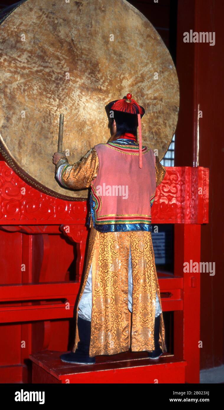 China: Zeremonieller Schlagzeuger im Trommelturm (Gulou), Peking. Der Trommelturm (Gǔlóu) und der Glockenturm (Zhōnglóu) wurden 1272 während der Regierungszeit von Kublai Khan (R. 1260–1294) errichtet. Kaiser Yongle (R. 1402–1424) baute die Türme 1420 wieder auf und sie wurden während der Regierungszeit des Qing-Kaisers Jiaqing (R. 1796–1820) wieder renoviert. Sowohl der Drum- als auch der Glockenturm wurden während der Yuan-, Ming- und Qing-Dynastien als Zeitmesser genutzt. Stockfoto