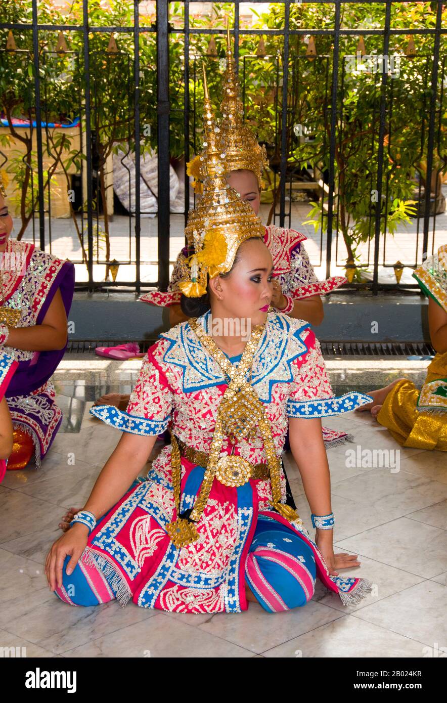 Thailand: Traditionelle thailändische Tänzer am Erawan-Schrein (San Phra Phrom), Bangkok. Der Erawan-Schrein, unter der Chit Lom Skytrain Station in Bangkok, repräsentiert den vierköpfigen hinduistischen gott der Schöpfung, Brahma, und wurde 1956 nach einer Reihe tödlicher Unglücksfälle errichtet, die den Bau des ursprünglichen Erawan Hotels erlitten hatten. Traditionelle thailändische Tänzer, die sich dauerhaft am Schrein befinden, werden angeheuert, um von Gläubigen zu tanzen, als Gegenleistung dafür, dass sie ihre Gebete am Schrein erhört haben. Stockfoto
