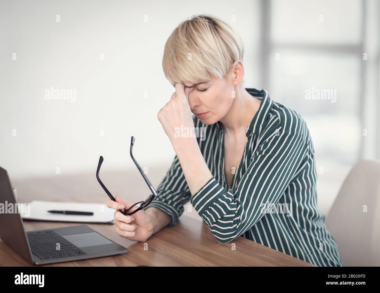 Dame Am Laptop Massiert Nosebridge Holding Brillen Sitzt Am Arbeitsplatz Stockfoto