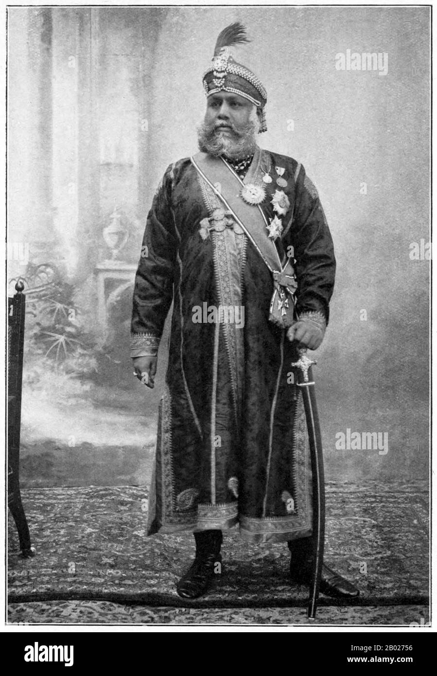 Indien: Maharaja Sawai Madho Singh II. Von Jaipur (28. August 1862 bis 7. September 1922), Rajasthan. Hochformat, ca. 1915. Madho Singh II. Wurde als Kunwar Kaim Singh Rajawat geboren, der Sohn eines kleinen Häuptlings, der mit dem herrschenden Kachwaha-Haus Jaipur verwandt war. Er wurde in seinem Teenager von seinem älteren Bruder ins Exil geschickt und in Armut gebracht, doch schließlich traf er auf den regierenden Sawai RAM Singh II., der ihn als seinen Nachfolger auf seinem Sterbebett adoptierte. Er wurde unter dem Namen Madho Singh gekrönt. Er nahm moderne Ideen von Bildung und sanitären Einrichtungen auf und baute Schulen, Krankenhäuser, Colleges und ein Museum in Jaipur. Stockfoto