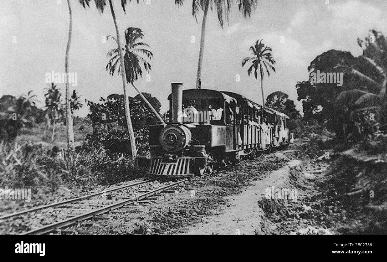 Tansania/Sansibar: Eine Dampflokomotive auf der Bububu-Bahn. Postkarte, 1910er Jahre Sansibar war das erste Land in Ostafrika, das die Dampflokomotive einführte. Sultan Bargash bin Said ließ 1879 von seinem Palast in Stone Town nach Chukwani eine 7 Meilen lange Eisenbahnstrecke bauen. Zunächst wurden die beiden Pullman-Wagen von Maultieren geschleppt, aber 1881 bestellte der Sultan eine 0-4-0 Panzerlokomotive bei den englischen Lokomotivbauern Bagnall. Die Eisenbahn war bis zum Tod des Sultans 1888 in Betrieb, als Gleis und Lokomotive verschrottet wurden. Stockfoto
