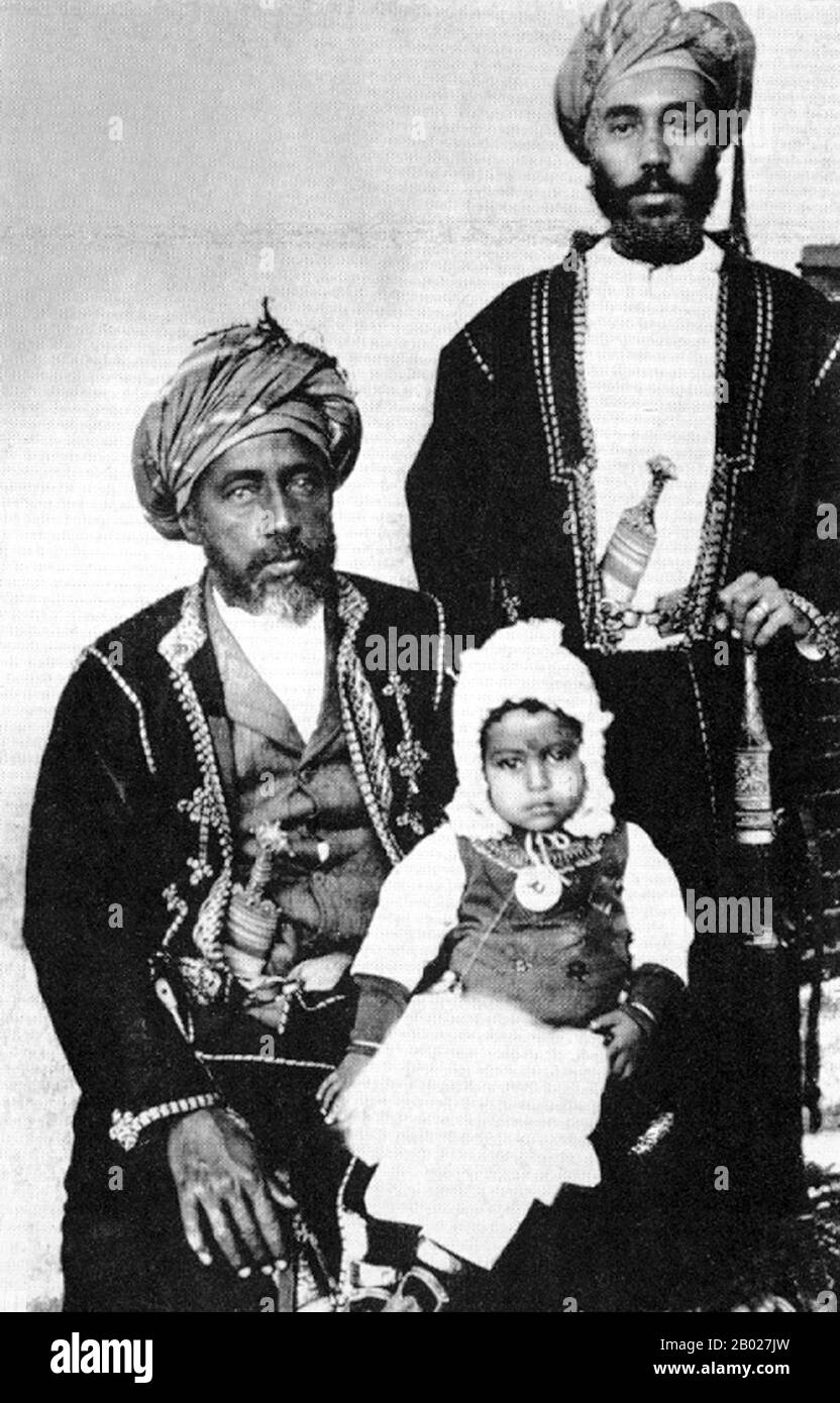 Oman: Sultan Faisal bin Turki (1864–4. Oktober 1913) mit seinem Sohn Taimur bin Faisal und seinem Enkel, Said bin Taimur, um 1913. Sayyid Faisal bin Turki, GCIE, historische Schreibweise Fessul bin Turkee, regierte vom 4. Juni 1888 bis 4. Oktober 1913 als Sultan von Maskat und Oman. Er folgte seinem Vater Turki bin Said als Sultan nach. Nach seinem Tod 1913 folgte ihm sein ältester Sohn Taimur bin Faisal. Als Faisal bin Turki 1888 die Macht übernahm, wurde seine Autorität über das Innere allmählich geschwächt, da die Stammesführer seine Abhängigkeit von britischen Beratern zunehmend als inhärente Schwäche wahrnahmen. Stockfoto