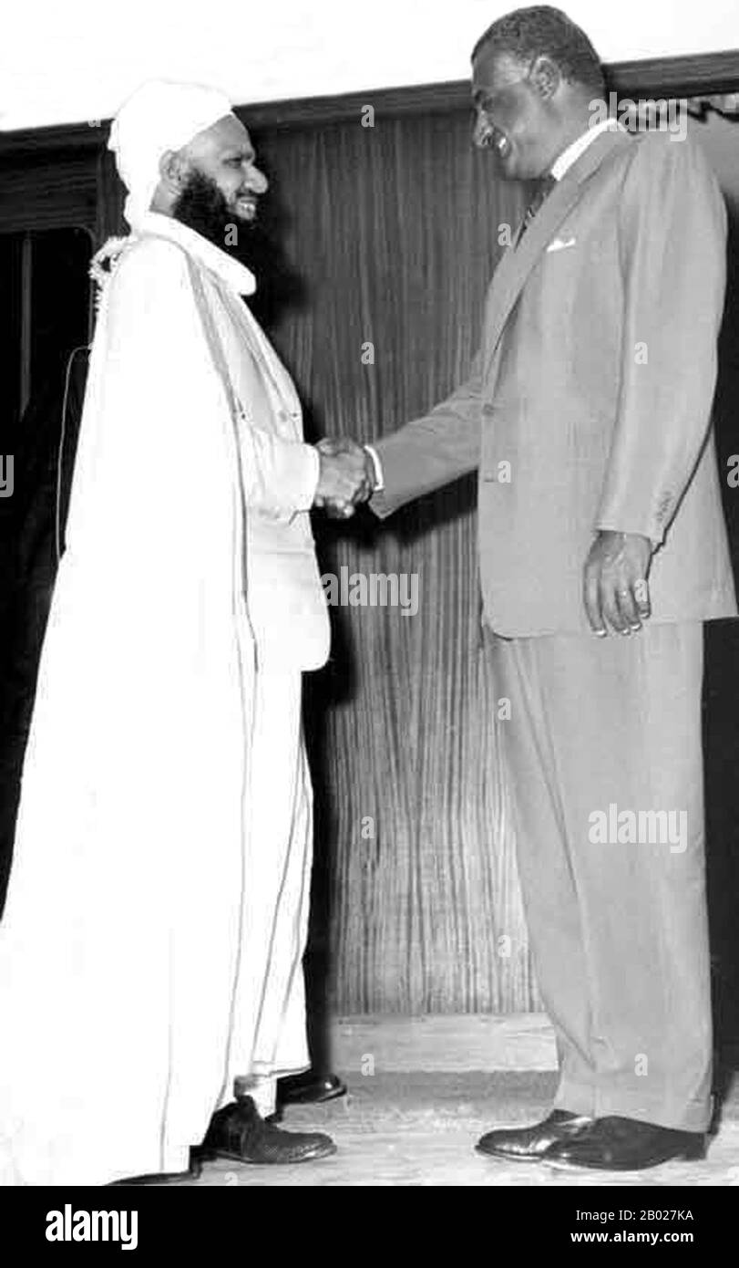 Oman: Imam Ghalib Ali Al Hinai (ca. 1908/1912 – 29. November 2009) mit Gamal Abdel Nasser (15. Januar 1918 – 28. September 1970) in Alexandria, Ägypten, 1959. Ghalib Ali Al Hinai war der letzte gewählte Imam des Imamats von Oman. Ab 1954 führte er den Imamat von Oman in Nizwa und Oman in der Jebel-Akhdar-Revolte gegen Sultan Said bin Taimur an. Der Krieg dauerte fünf Jahre, bis die Streitkräfte des Sultans von Oman, unterstützt von britischen Kolonialsoldaten des Special Air Service, 1959 die Jebel-Akhdar-Revolte niedergeschlagen hatten. Imam Ghalib Al Hinai gelang es, nach Saudi-Arabien zu fliehen. Stockfoto