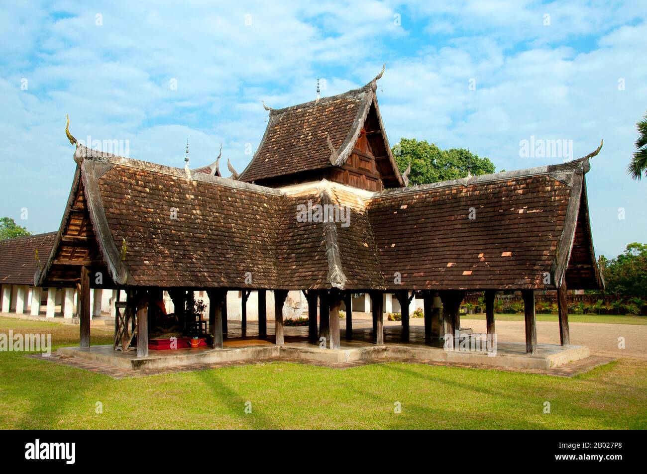 Wat Ton Kwen (วัด ต้น เกว๋น), eher bekannt als Wat Inthrawat (วัด อินทราวาส), bedeutet "Tempel der Zuckerpalmen" in kham muang oder Nordthailand und sicher genug, dass der rustikale Tempel, der in einem kleinen Dorf inmitten von grünen Reisfeldern liegt, von hohen und eleganten Zuckerpalmen umgeben ist. Wat Ton Kwen, erbaut zu Beginn der Herrschaft von Chao Kawilorot (1856-70) im Jahr 1856, gehört zu den besten und reinsten Beispielen, die die traditionelle Holzarchitektur Des LAN Na im 19. Jahrhundert überdauern. Zweifellos ist sie wegen ihrer geringen Größe und ihrer relativen Isolation von den "Verbesserungen" und anderen Entrüsten verschont geblieben Stockfoto