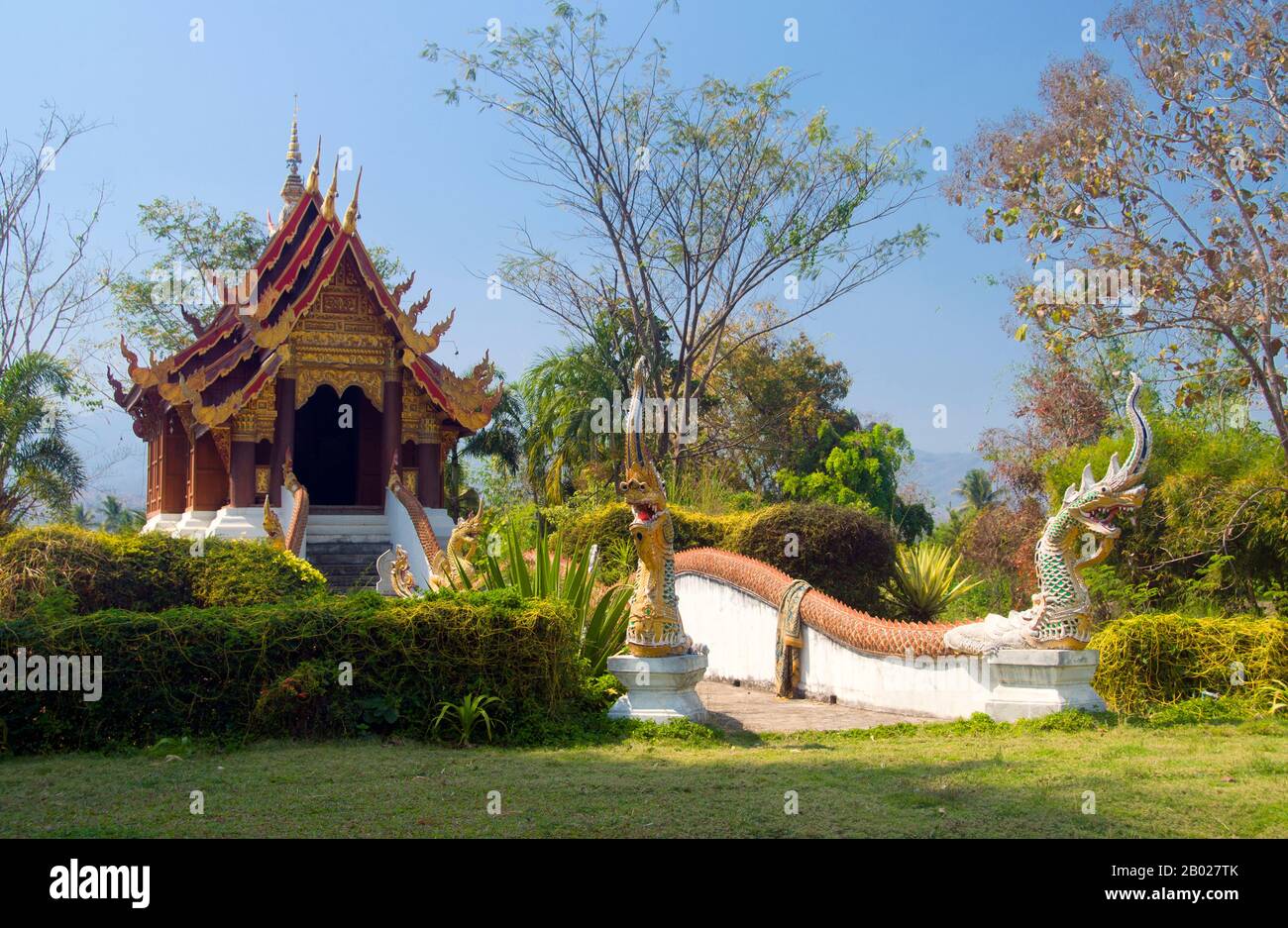 Wat Pa Daet (วัดป่าแดด), der Name - "unleuchtete Wälder" - deutet darauf hin, dass es sich früher um einen Waldtempel handelte. Ein ummauertes Gehäuse enthält einen Viharn, einen Sala- und einen HO-Trai oder eine Bibliothek, während etwas außerhalb ein Ubosot im traditionellen nördlichen Stil steht, der von einem schmalen Wassergraben umgeben ist. Der Viharn stammt aus dem Jahr 1877 und wurde Mitte der 1980er Jahre aufwändig restauriert. Das in Schwarz und Gold dekorierte dreistufige Dach fegt im typischen Lan Na-Stil tief, mit aufwendigen geflügelten Giebeln, die aufflackernde Naga unterstützen. Die Stufen zum Portikus werden von Chinthe Löwen im birmanischen Stil und Naga-makara Balustraden mit dem Kinn bewacht Stockfoto